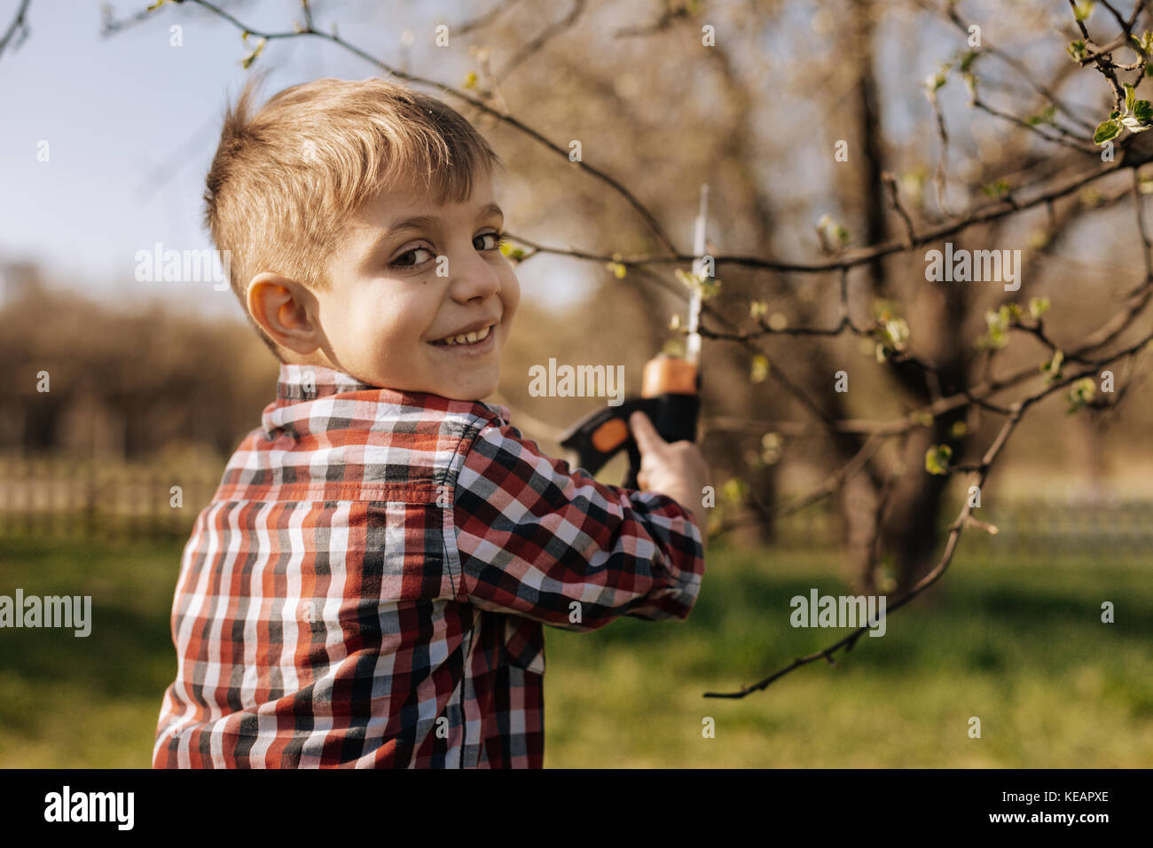 Lächelnd kind Vorbereitung Bäume für den Frühling Stockfoto