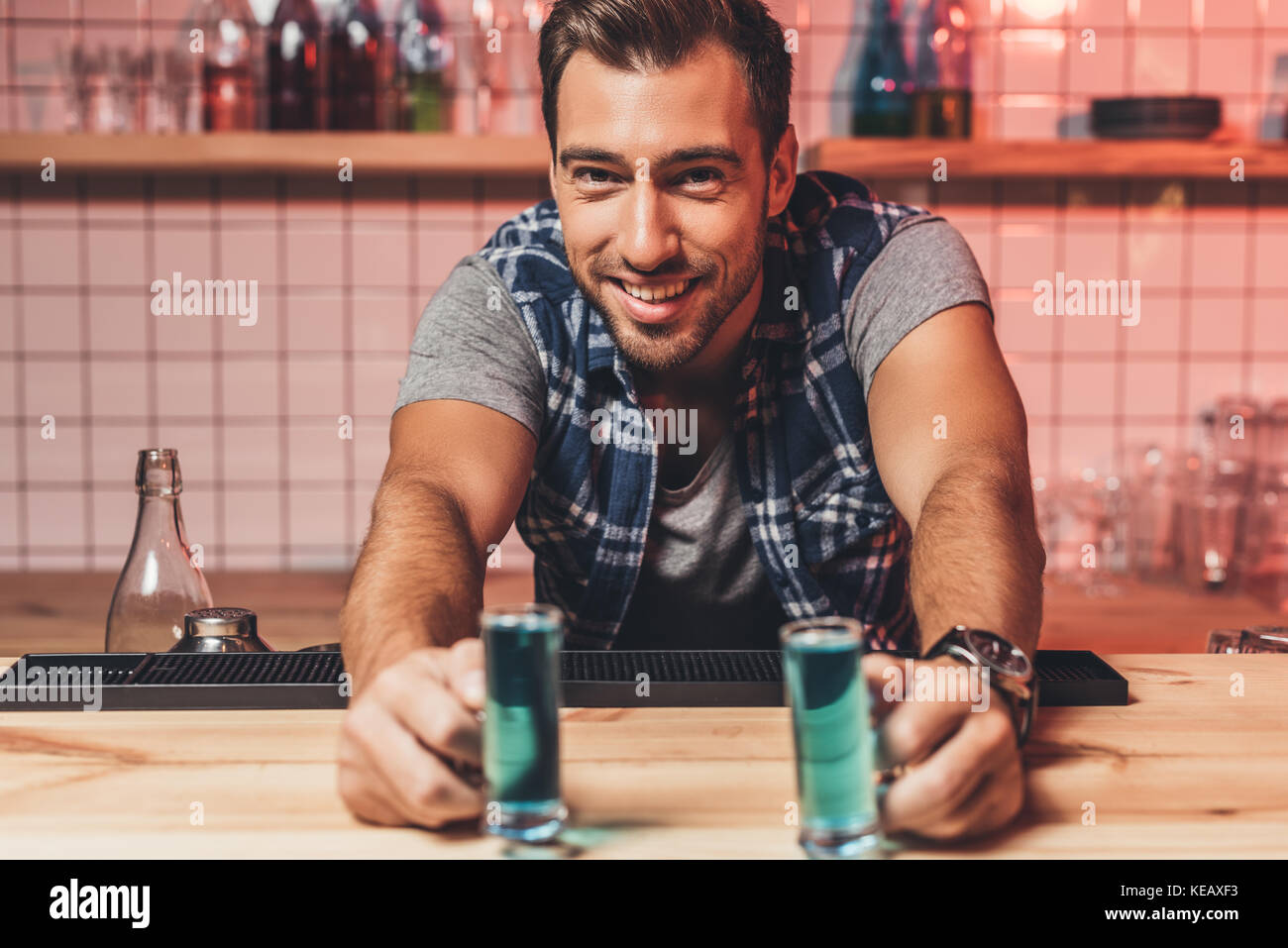 Barkeeper mit Alkohol Schüsse auf Zähler Stockfoto