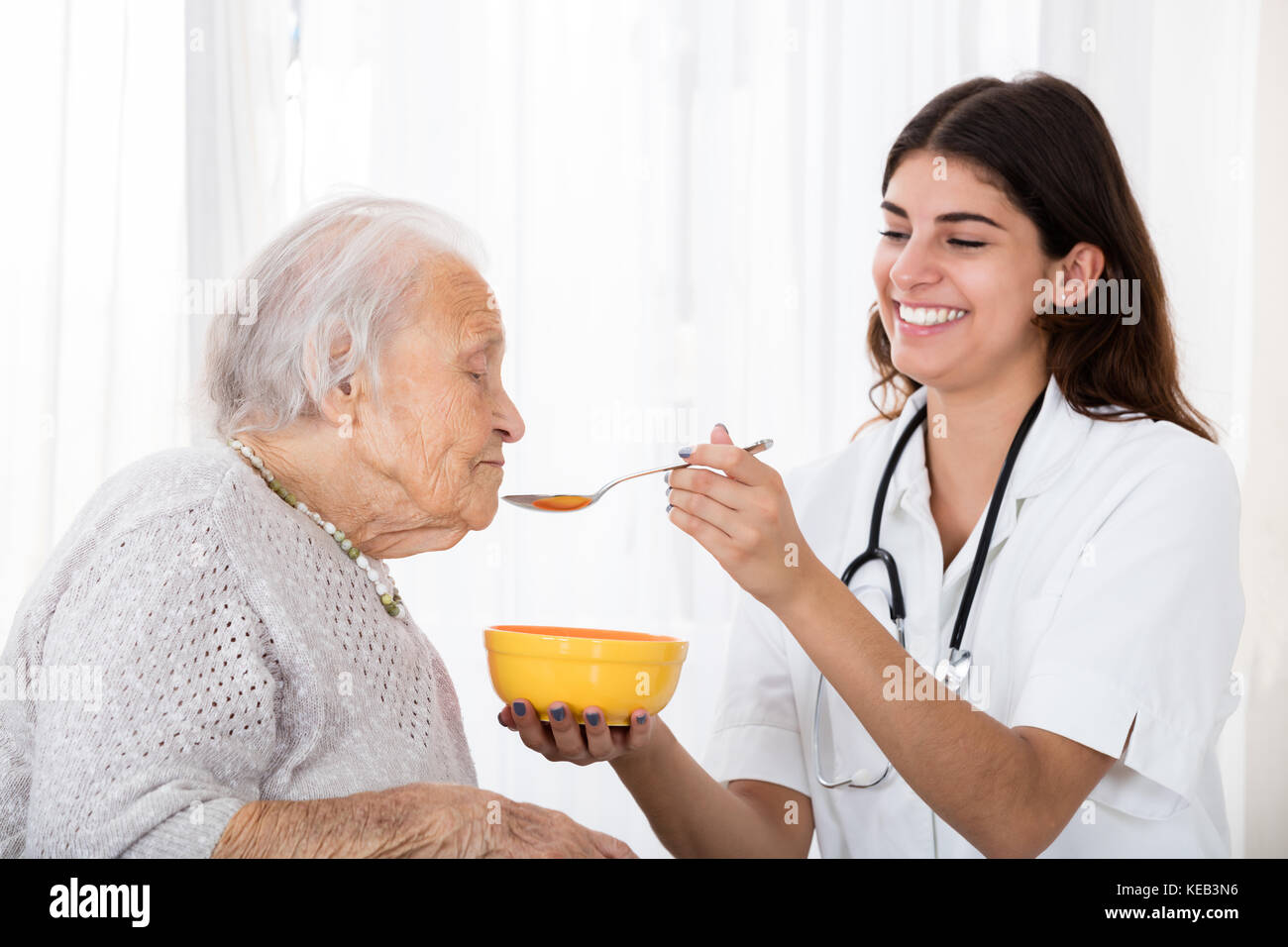 Gerne Ärztin Fütterung Suppe mit Löffel zu den älteren Patienten im Krankenhaus Stockfoto Gerne Ärztin Fütterung Suppe mit Löffel zu den älteren Patienten im Krankenhaus Stockfoto