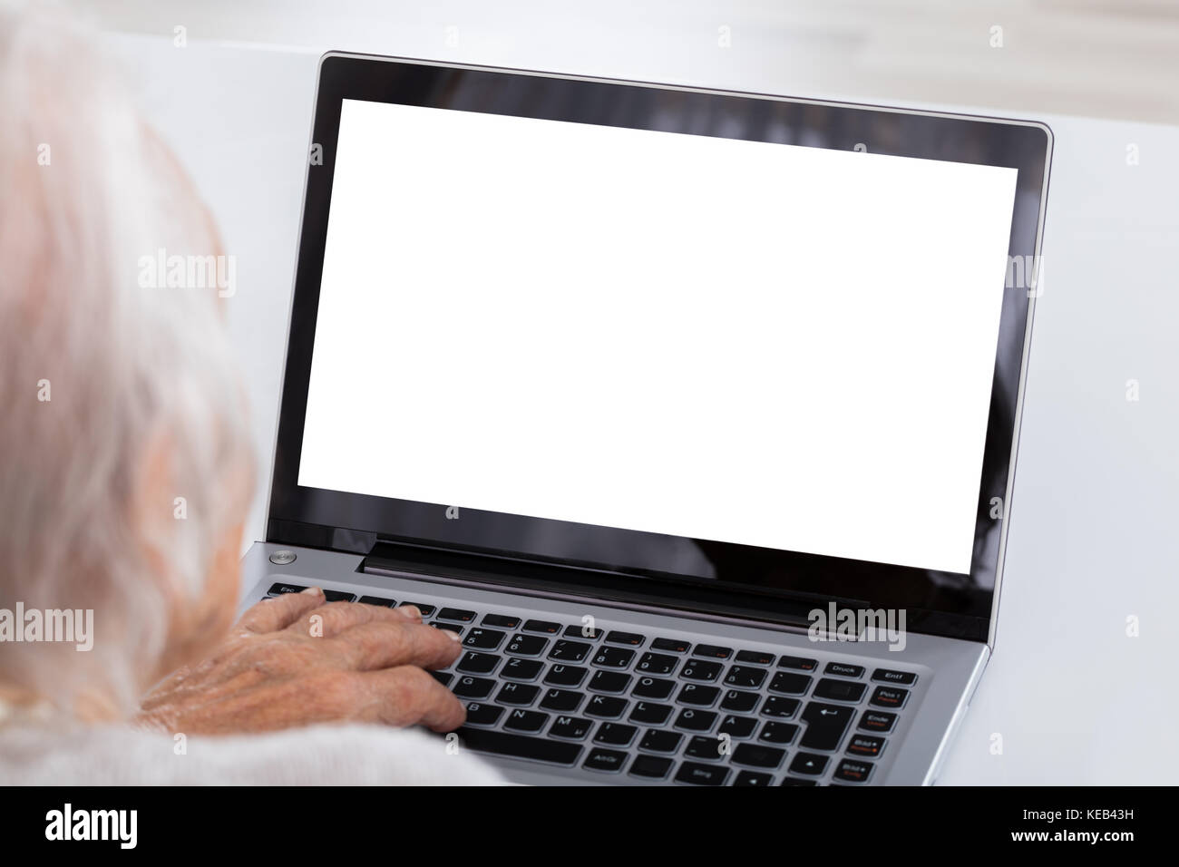 Nahaufnahme der älteren Frau mit Laptop zeigt leeren Bildschirm zu Hause Stockfoto