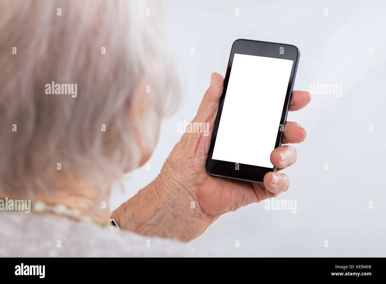 Nahaufnahme der älteren Frau mit Smartphone mit leeren Bildschirm zu Hause Stockfoto