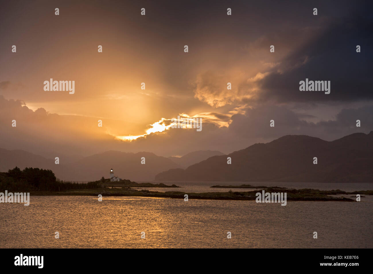 Dramatische dawn Licht und Sonnenstrahlen an ornsay Leuchtturm auf der Insel Eilean Sionnach aus der Halbinsel Sleat, Isle of Skye, Highland, Schottland, UK Stockfoto