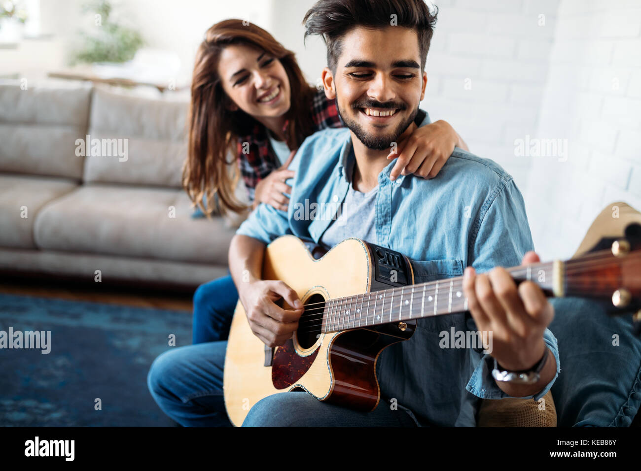 Jungen gutaussehenden Mann Gitarre spielen für seine Freundin Stockfoto