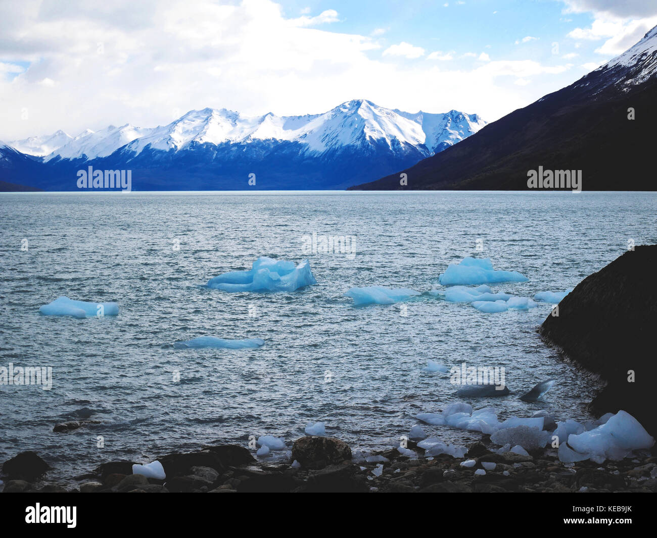 Blaue Eisberge in den Lago Argentino mit Bergkulisse, Patagonien, Argentinien Stockfoto