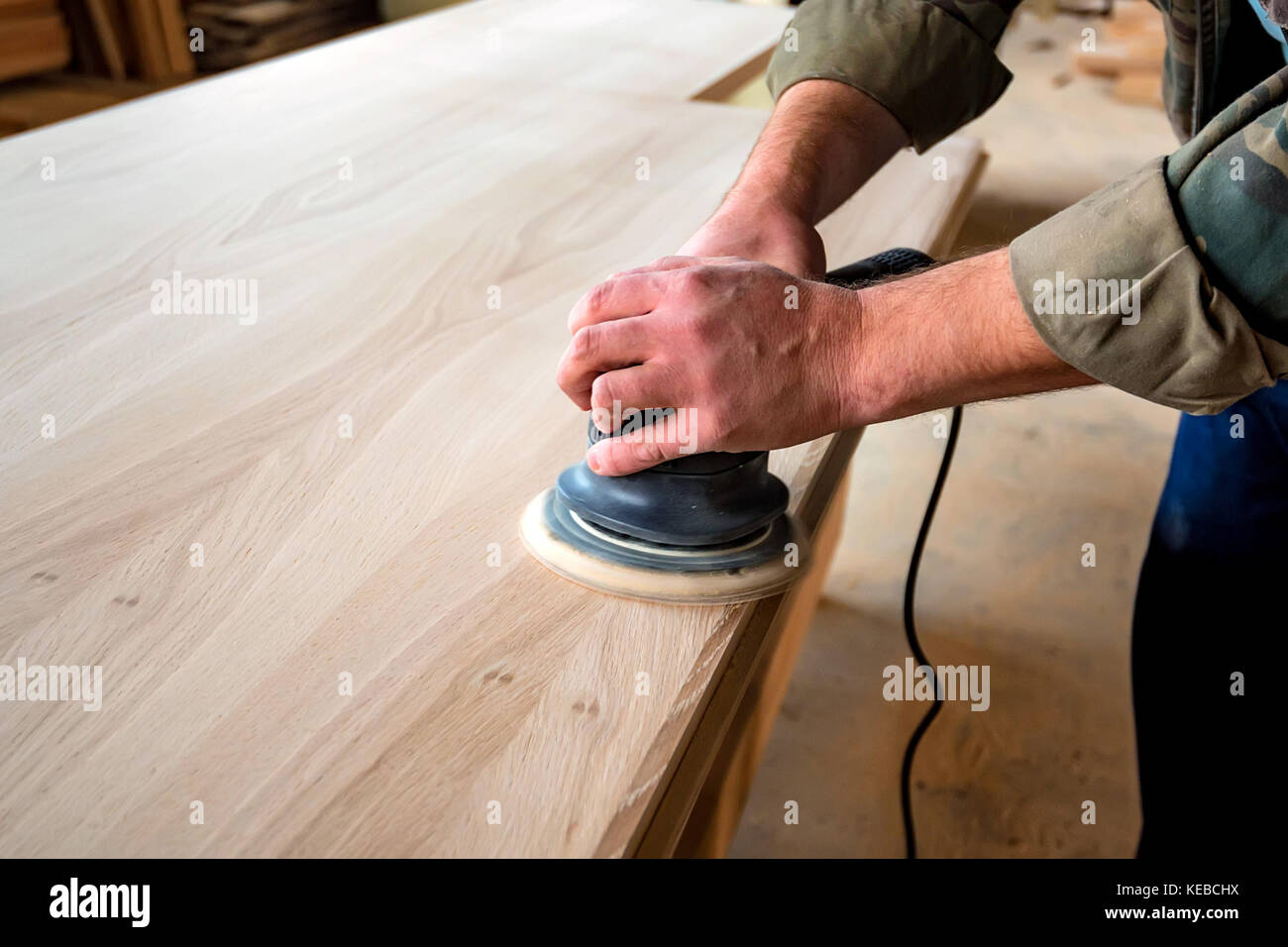 Man Schleifen von Holz mit Schwingschleifer in einem Workshop Stockfoto