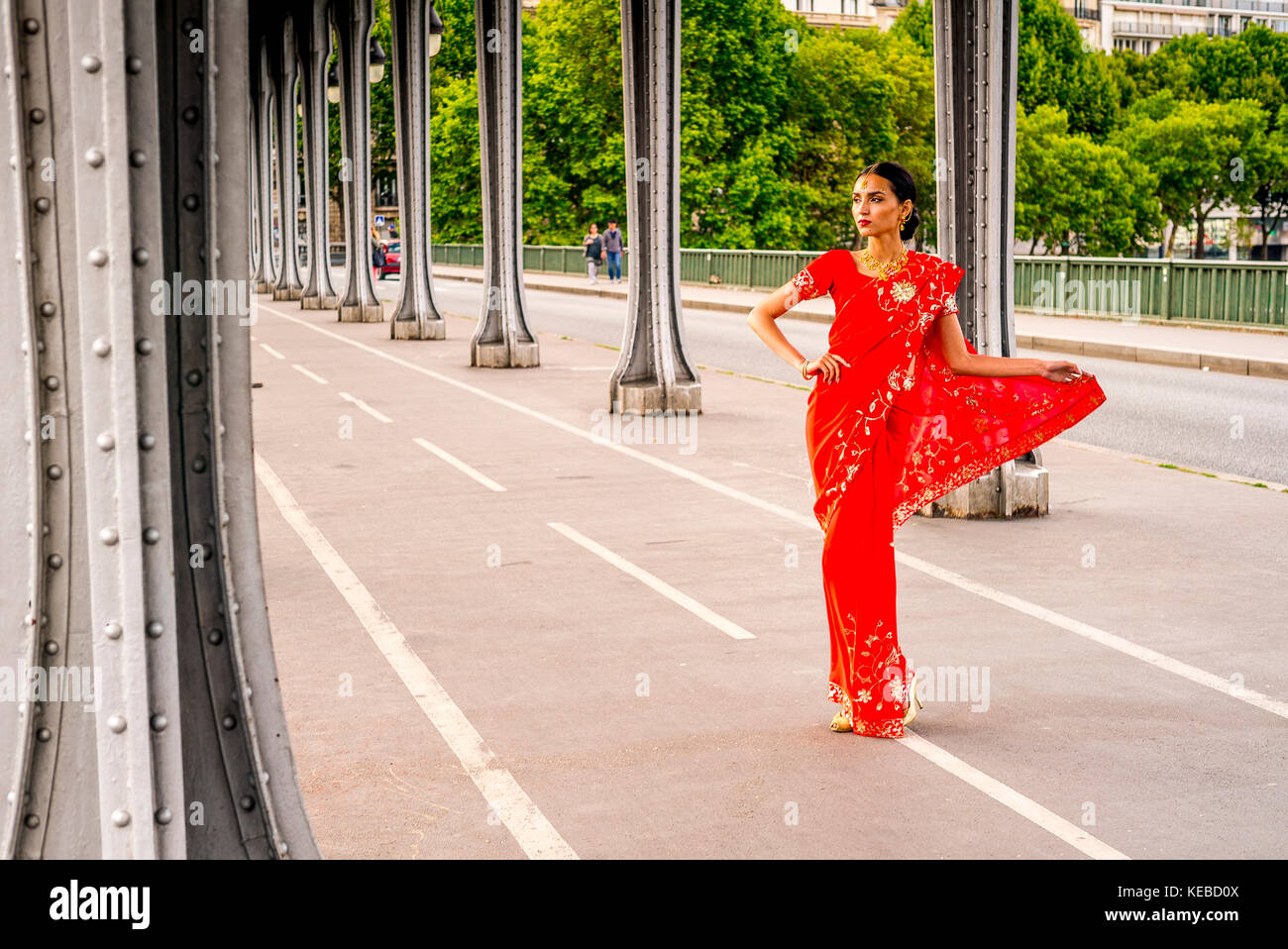 Schöne junge Frau in einem roten Sari auf der Pont Bir Hakeim gekleidet - in Paris. Stockfoto