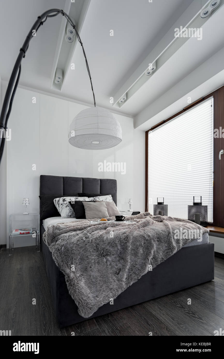 Einfache Schlafzimmer mit Doppelbett und moderne, weiße Lampe Stockfoto