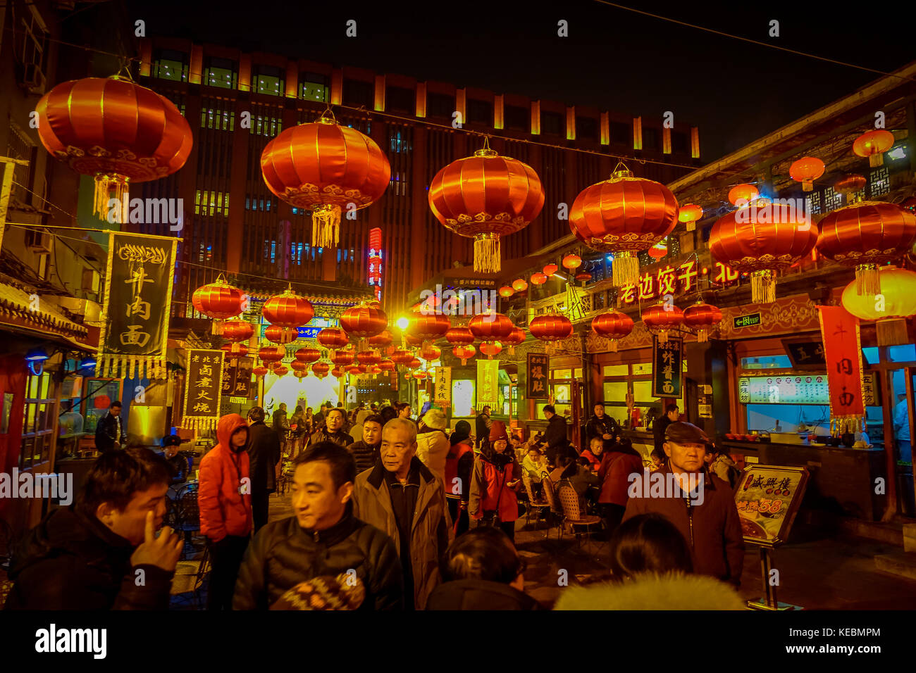 PEKING, CHINA - 29. JANUAR 2017: Menschen spazieren durch charmante Straßen mit kleinen Restaurants, traditioneller Architektur und Dekoration, lokalem Donghuamen-Lebensmittelmarkt-Konzept Stockfoto