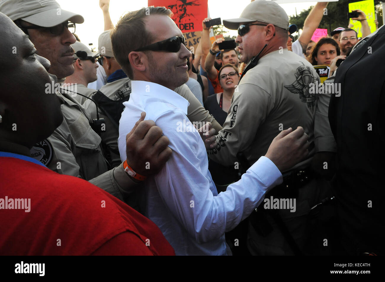 Gainesville, Florida, USA. 19 Okt, 2017. Ein Anhänger des weißen nationalistischen Richard Spencer von der Polizei für seine eigene Sicherheit begleitet ist, wie er an die Demonstranten nach der Spencer Rede an der Universität von Florida am 19. Oktober 2017 in Gainesville, Florida. Hunderte von Polizeibeamten waren an Hand der Demonstranten zu steuern. Credit: Paul Hennessy/alamy leben Nachrichten Stockfoto