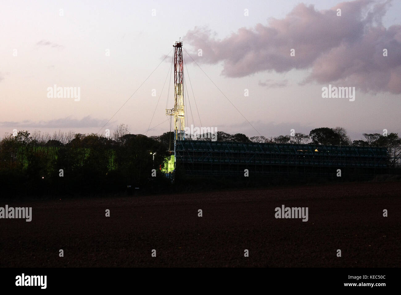 York, North Yorkshire, Großbritannien. Oktober 2017. Ein hydraulisches Fracking-Rig, das einige hundert Meter vor den Anti-Fracking-Protesten im Besitz von ''Third Energy'' ist, beginnt seine abendlichen Betriebslichter, während die Nacht über die Felder zieht.zwei Anti-Fracking-Demonstranten aus dem Anti-Fracking-Lager Kirby-Misperton in North Yorkshire wurden verhaftet, kurz nachdem sie eine 24-stündige Sperre für ein Holz beendet hatten Turm, der das Haupttor der Fracking Company ''Third Energy''' in North Yorkshire blockierte. Die Polizei von North Yorks übertraf die Zahl der Demonstranten, die sich gegen beide mit schweren Händen und Hinderungsmaßnahmen widersetzten Stockfoto