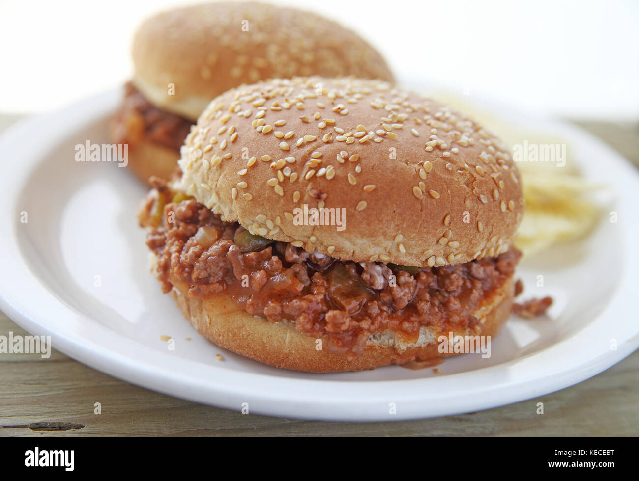 Zwei Sloppy Joe Sandwiches auf Sesam Brötchen mit Kartoffelchips und Raum für Text Stockfoto