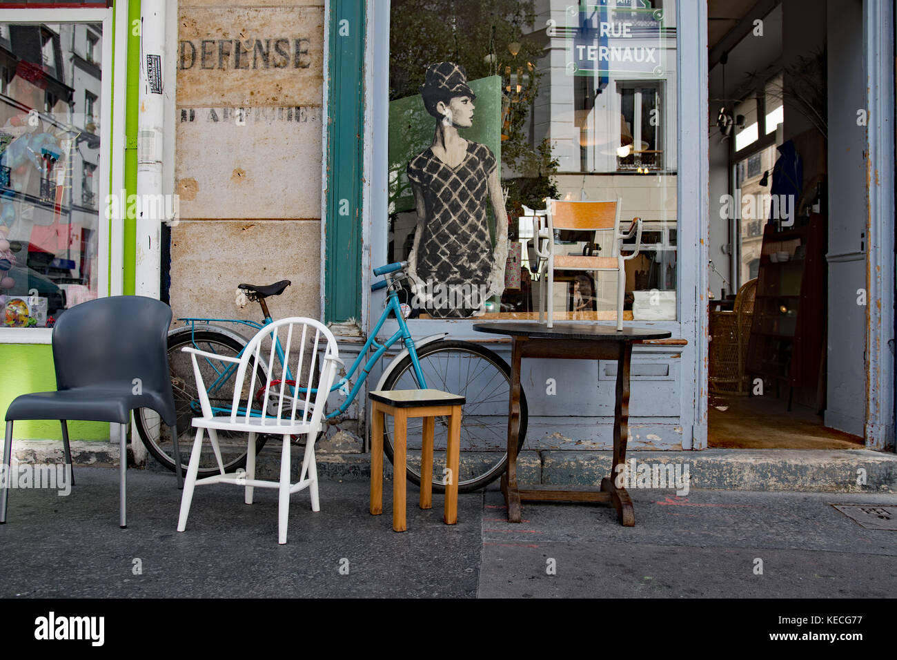 Vintage Stühle und Fahrrad vor einem Schaufenster Stockfoto