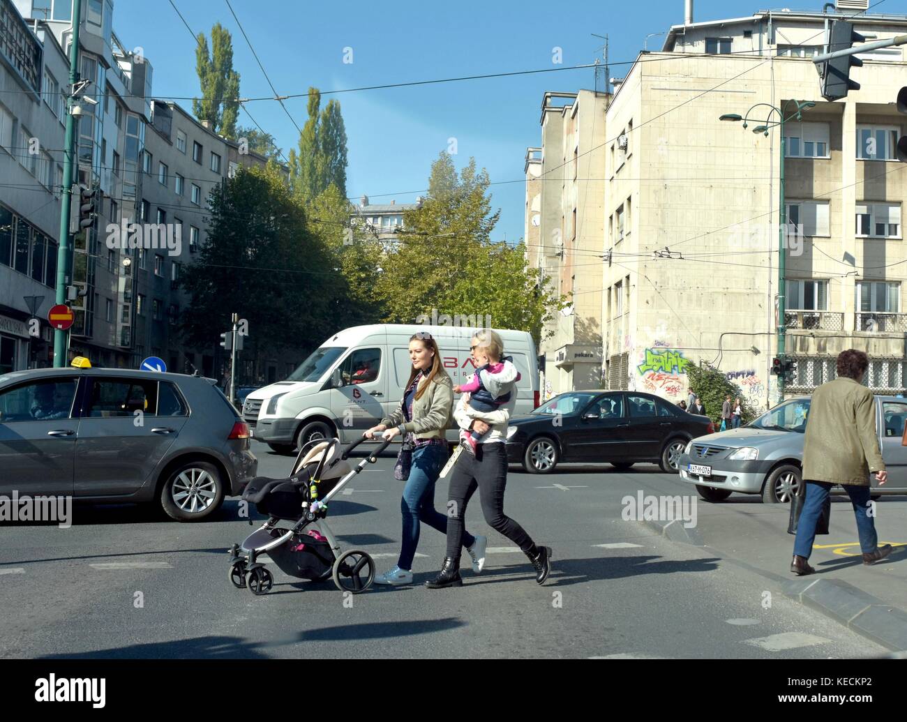 Zwei Frauen überschreiten Straße mit Kinderwagen auf Ampel Stockfoto