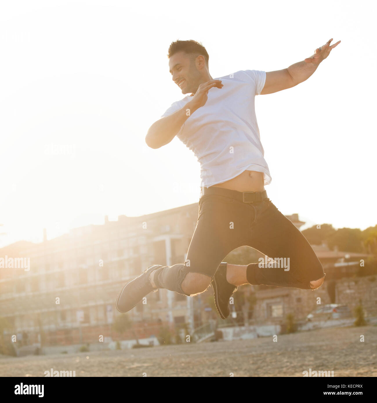 Portrait bei Sonnenuntergang von einem schönen jungen Mann springen mit Energie. Stockfoto
