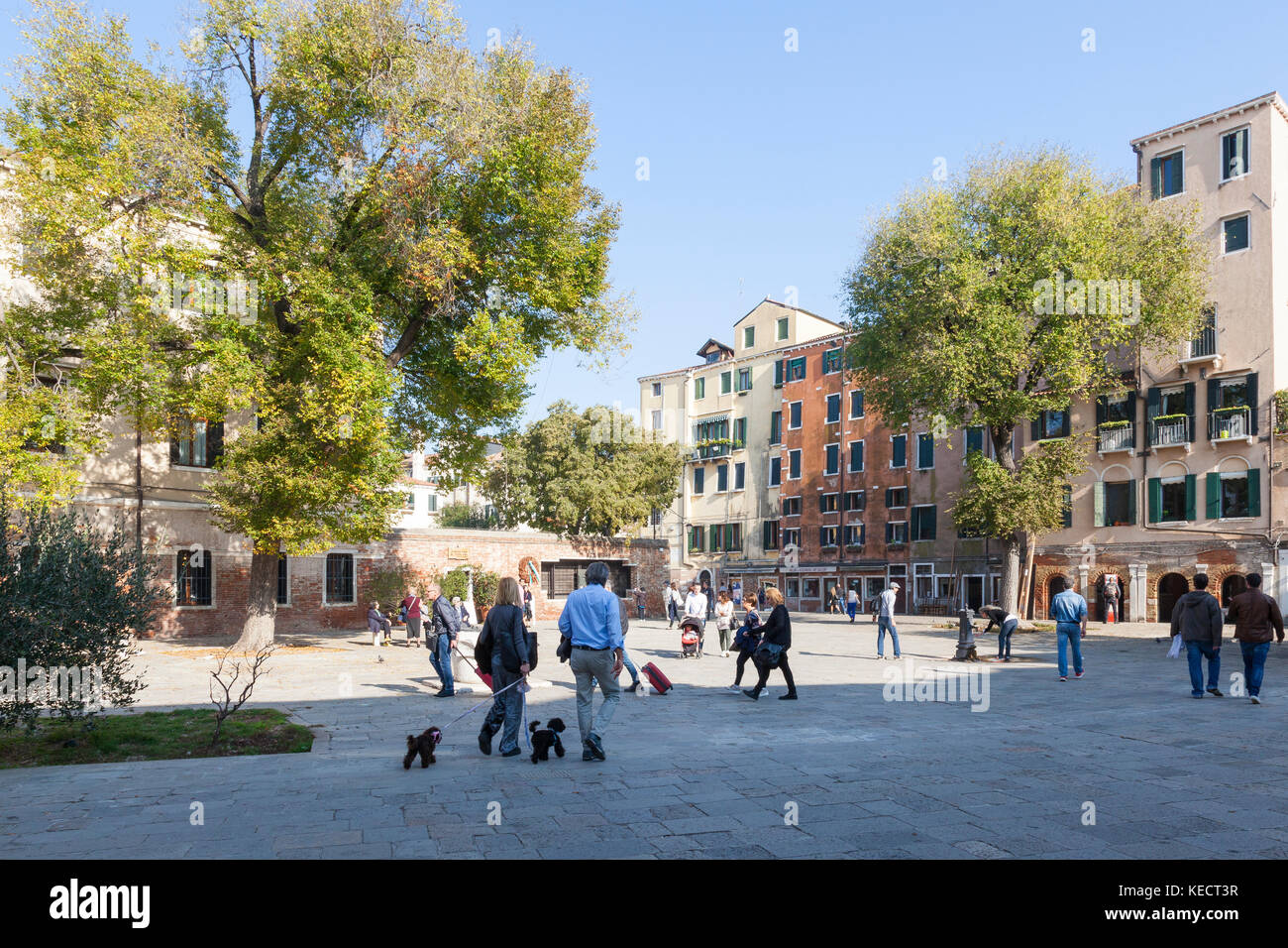 Die Einheimischen gehen, über ihren Alltag und ein paar Touristen in das Jüdische Ghetto in Campo De Gheto Novo, Cannaregio, Venice, Italien Stockfoto