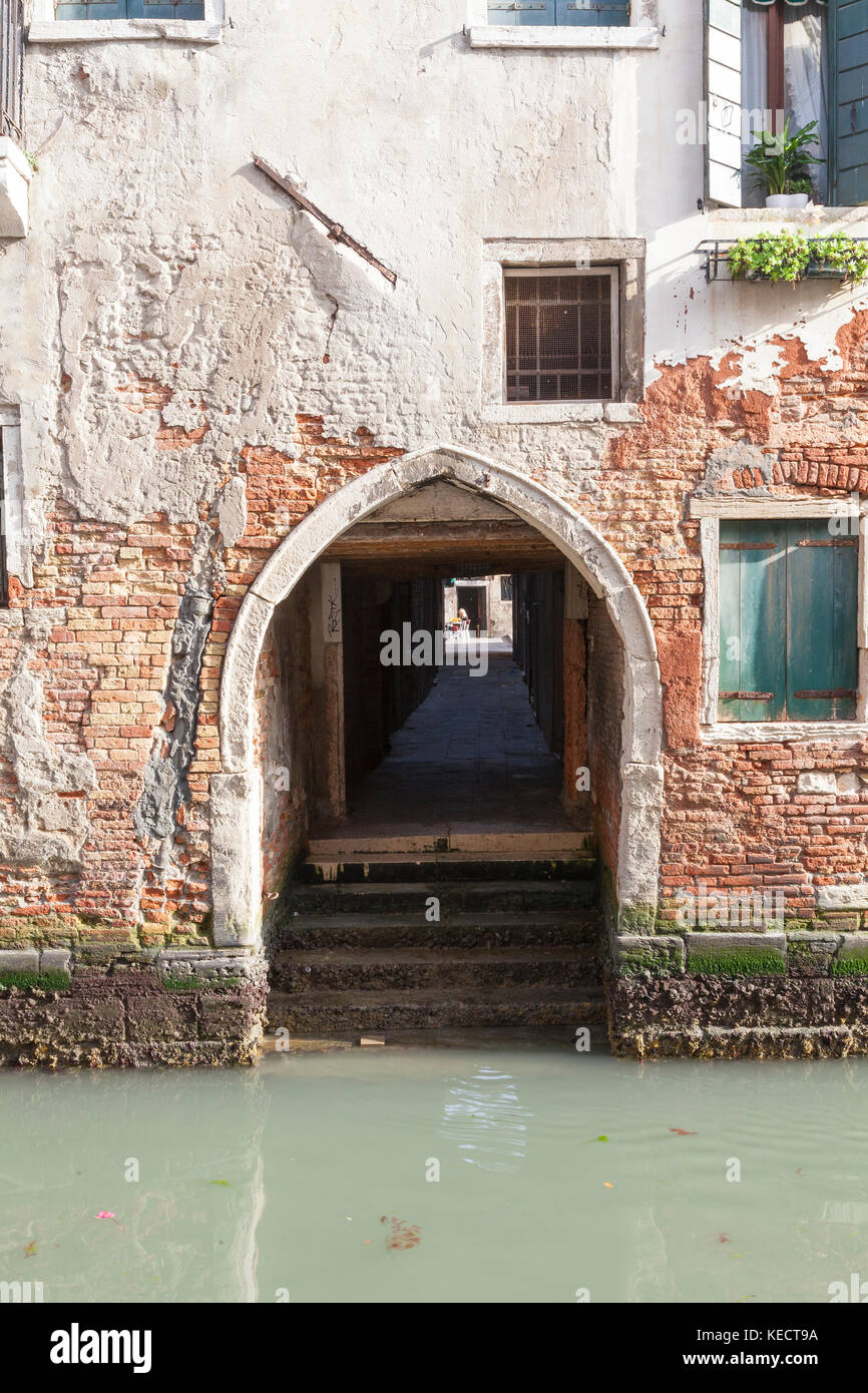 Alte historische gewölbten Eingang vom Wasser, Cannaregio, Venice, Italien führt zu einer überdachten Passage oder sotoportego, mit einer Öffnung auf einem Platz oder den Campo i Stockfoto