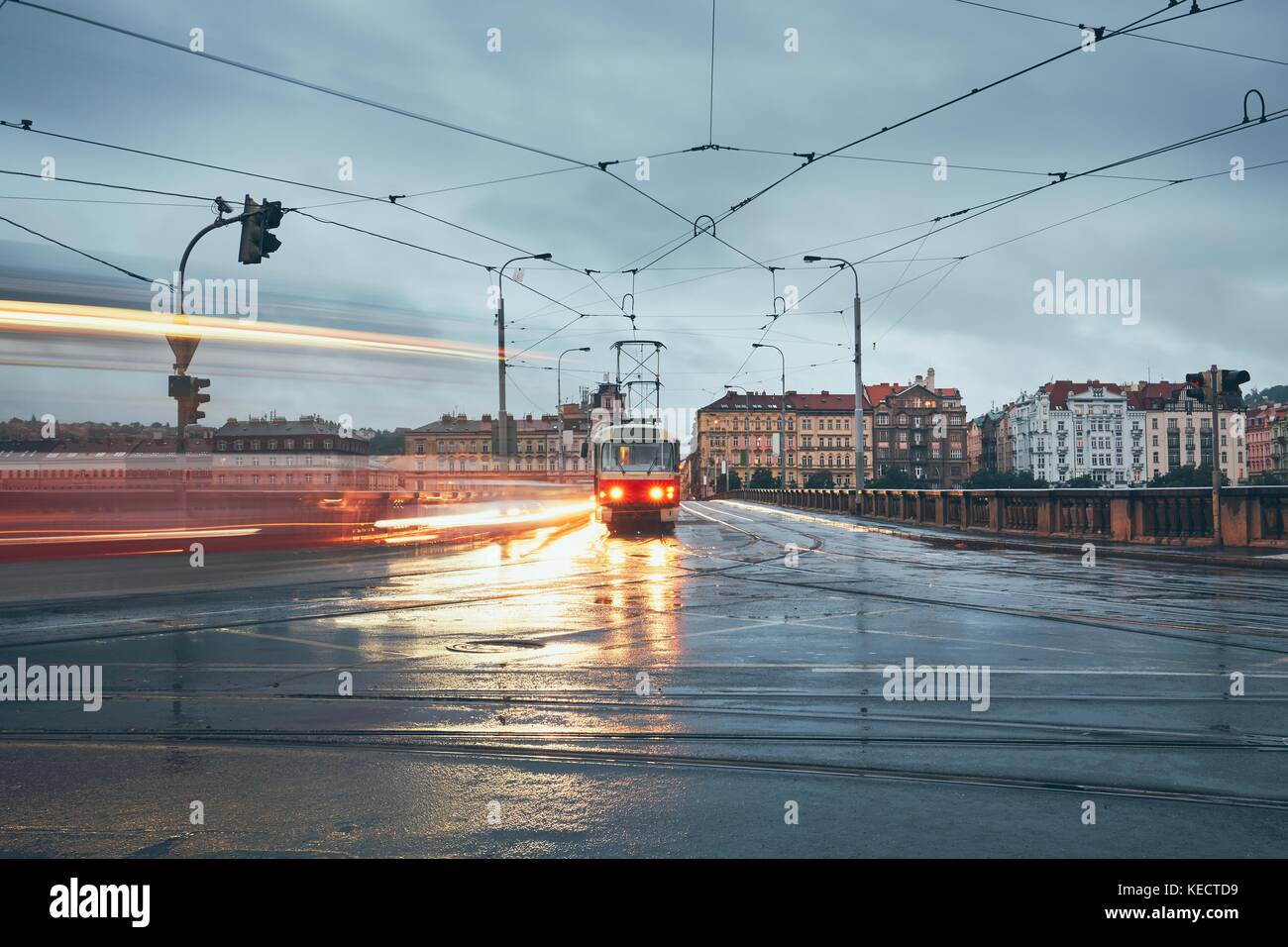 Düsterer Tag in der Stadt. Mit der Straßenbahn an der Kreuzung im Regen. Prag, tschechische Republik. Stockfoto