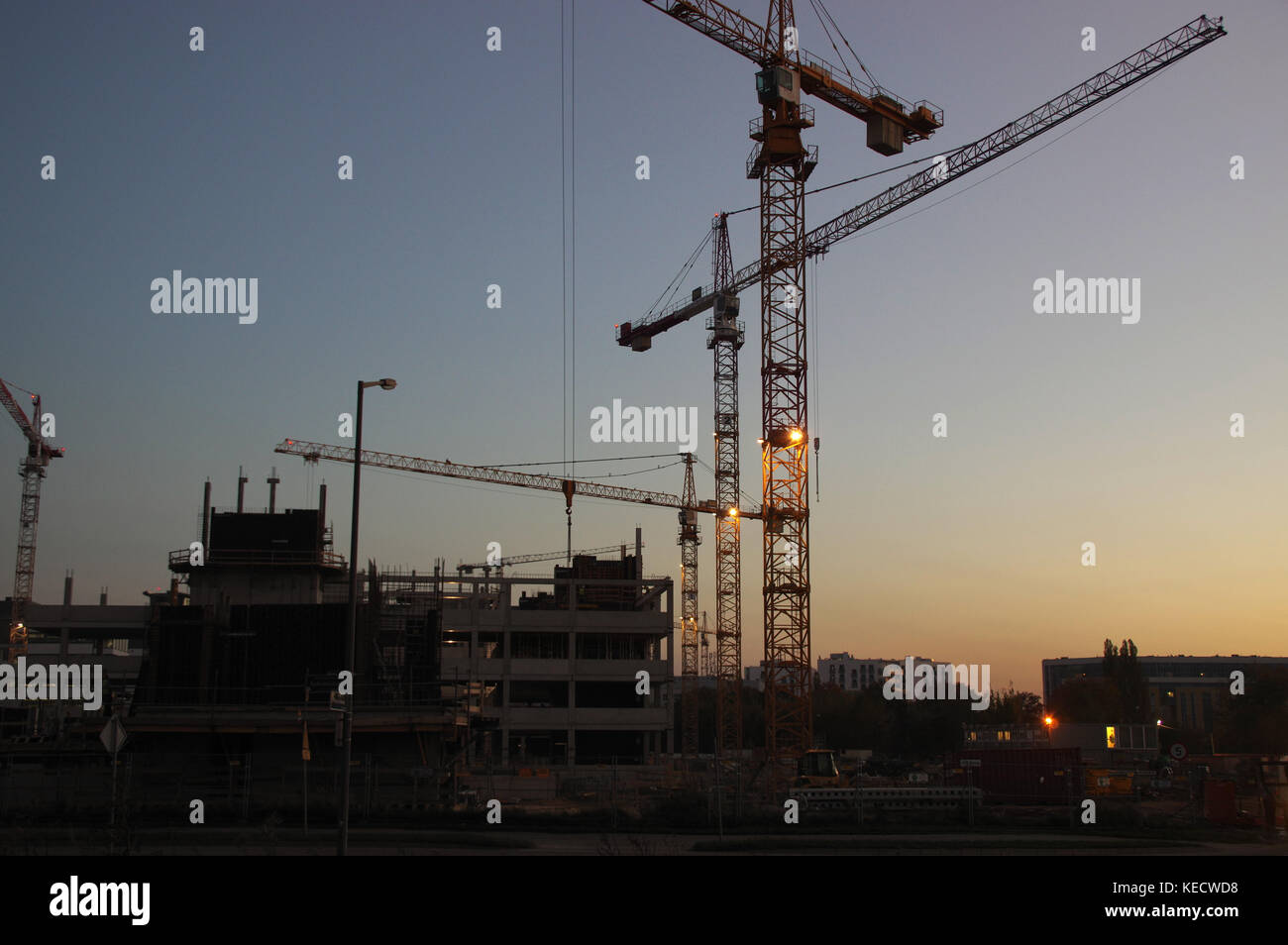 Bau neuer Wohnungen. Silhouetten von Kranen auf dem Hintergrund der Abendhimmel. Stockfoto