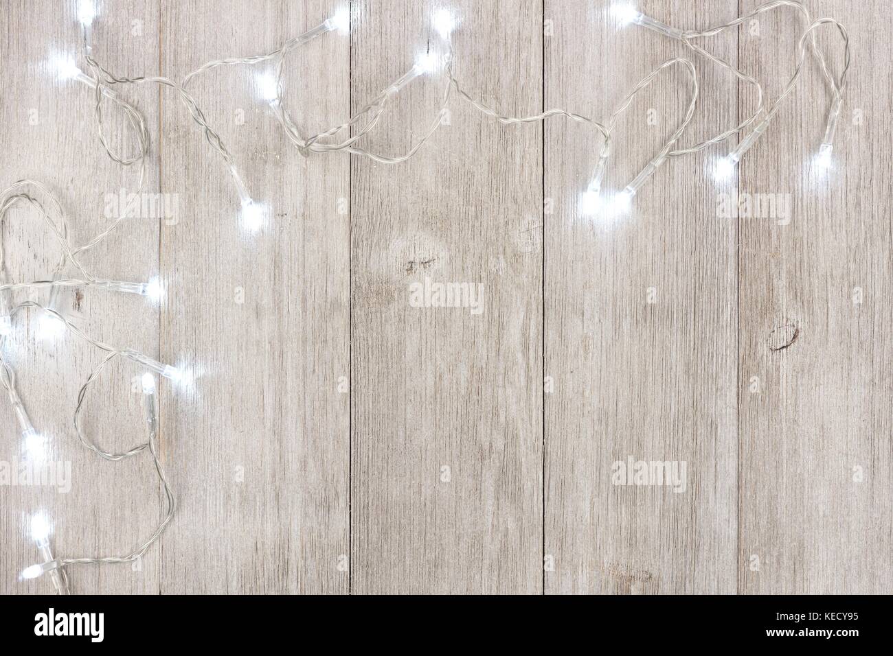 White Christmas lights Ecke Grenze, oben Blick auf ein helles Grau Holz Hintergrund Stockfoto