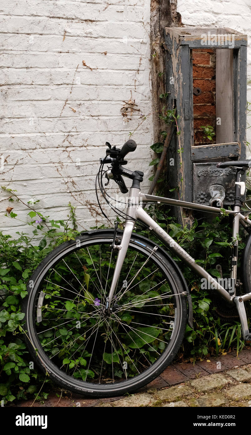 Juni 2017 - Modern Fahrrad links gegen eine alte Mauer in Thame, Oxfordshire, England. Stockfoto