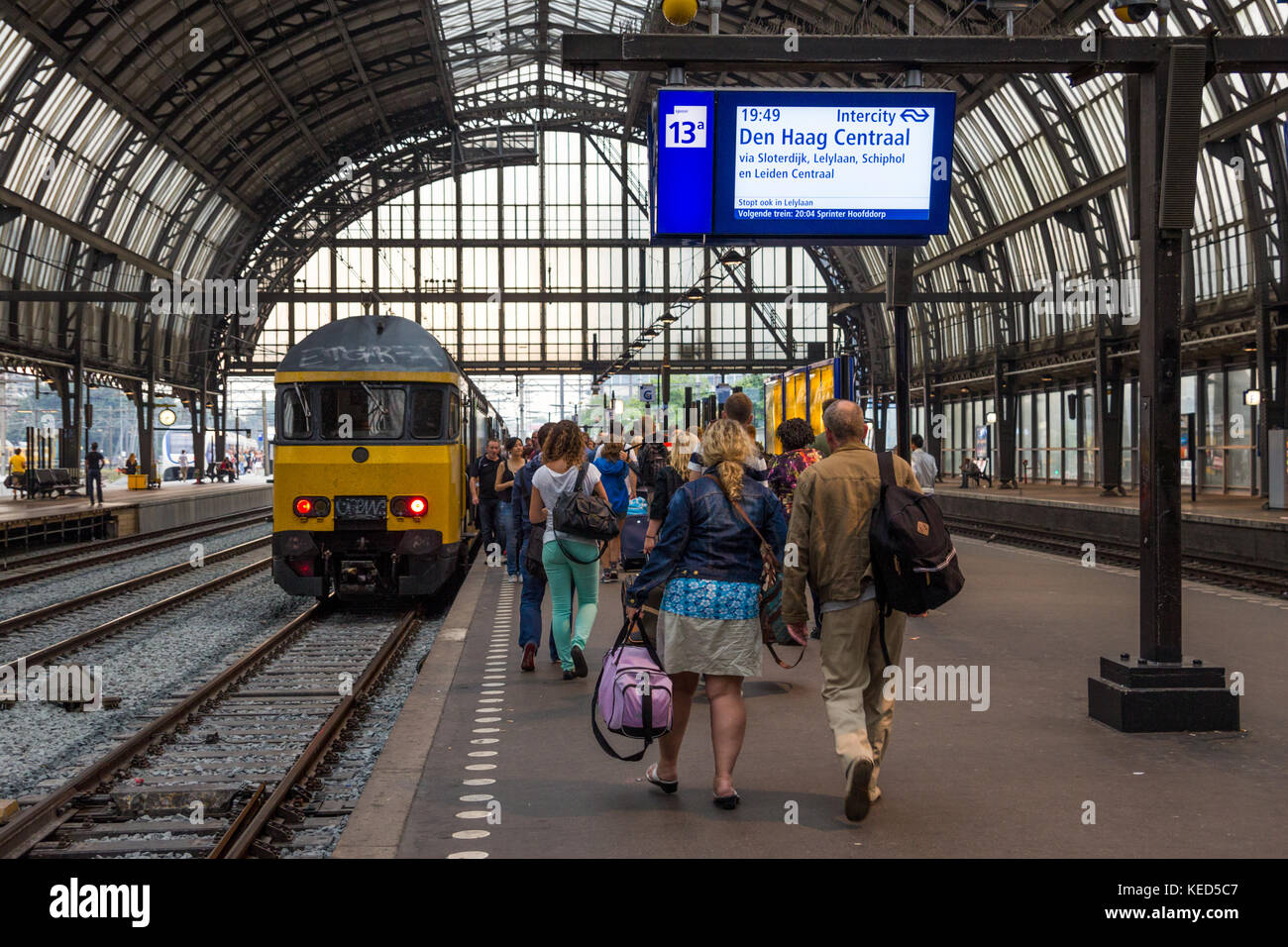 Amsterdam, Niederlande, 27.Juli 2012: Passagiere einer regionalen Zug am Hauptbahnhof ein. Stockfoto