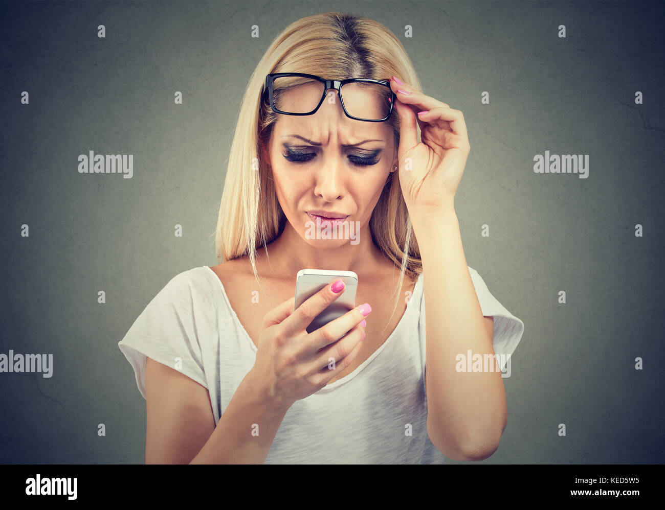 Closeup Portrait einer Frau mit Brille Probleme sehen Handy hat Vision Probleme. verwirrend Technologie Stockfoto