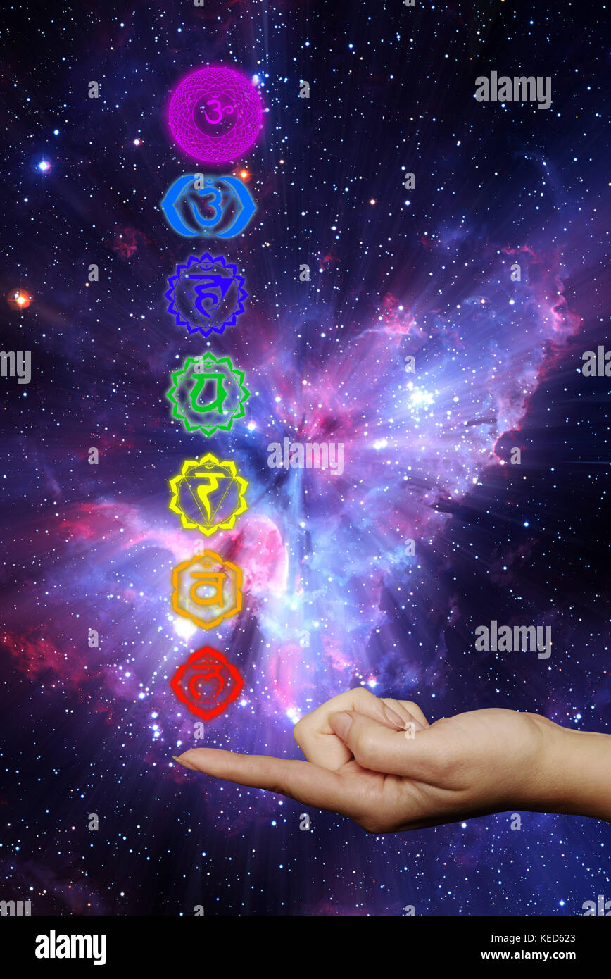 Bunte Chakra-Symbole mit einer weiblichen Hand halten sie auf Die Spitze eines Fingers Stockfoto