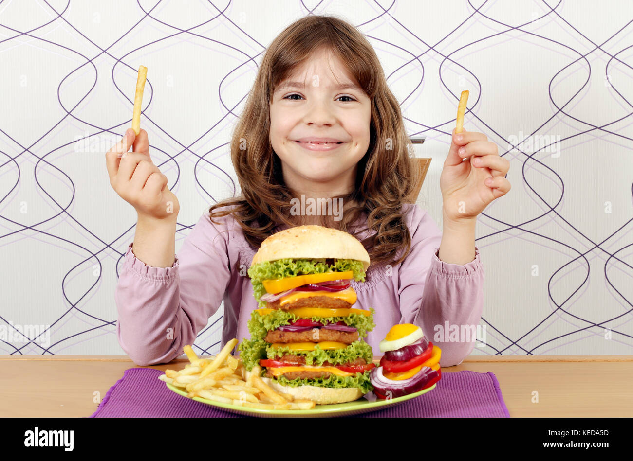 Kleines Mädchen mit großen Hamburger und Pommes Frites Stockfoto