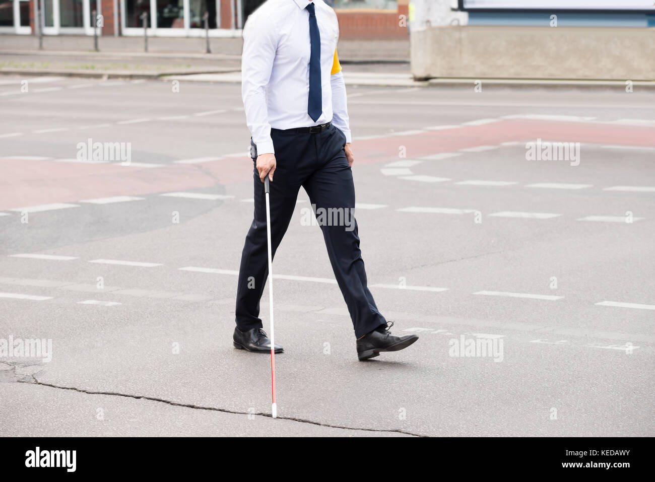 Blinde Person mit weißem Stick gehen auf die Straße Stockfoto