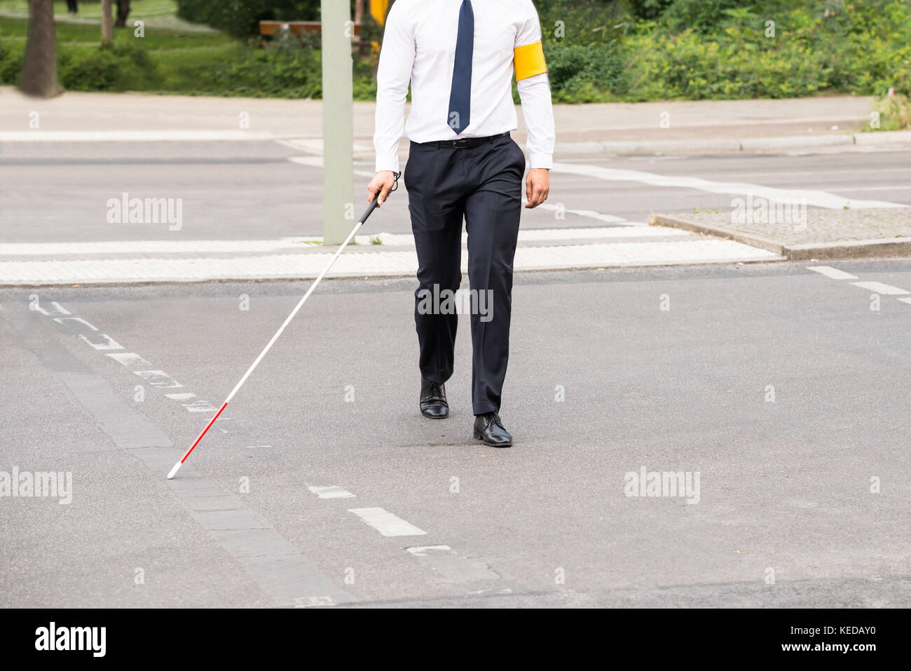 Blinde Person mit weißem Stick gehen auf die Straße Stockfoto