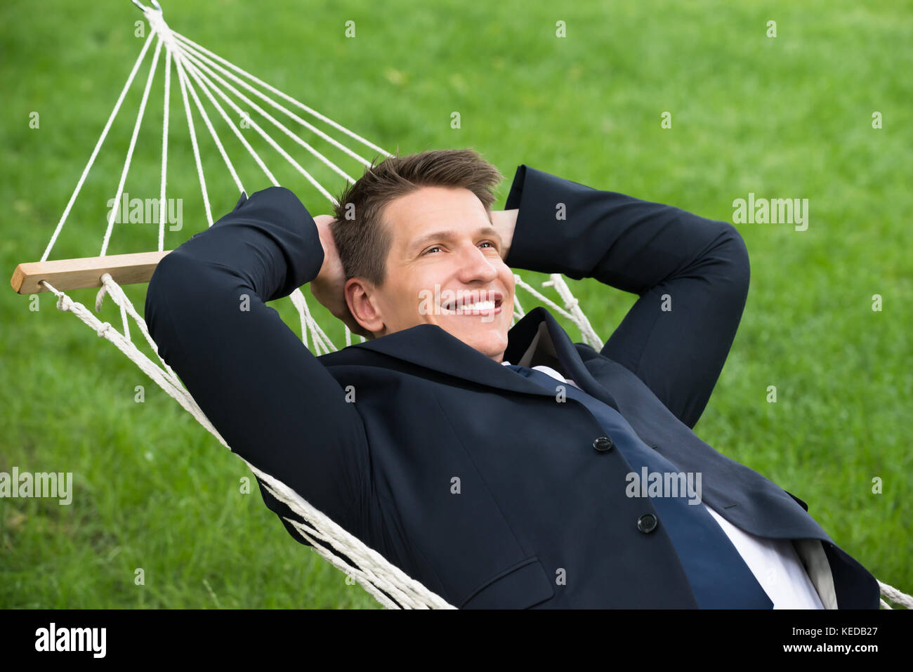 Glückliche junge Unternehmer in der Hängematte im Park liegend Stockfoto