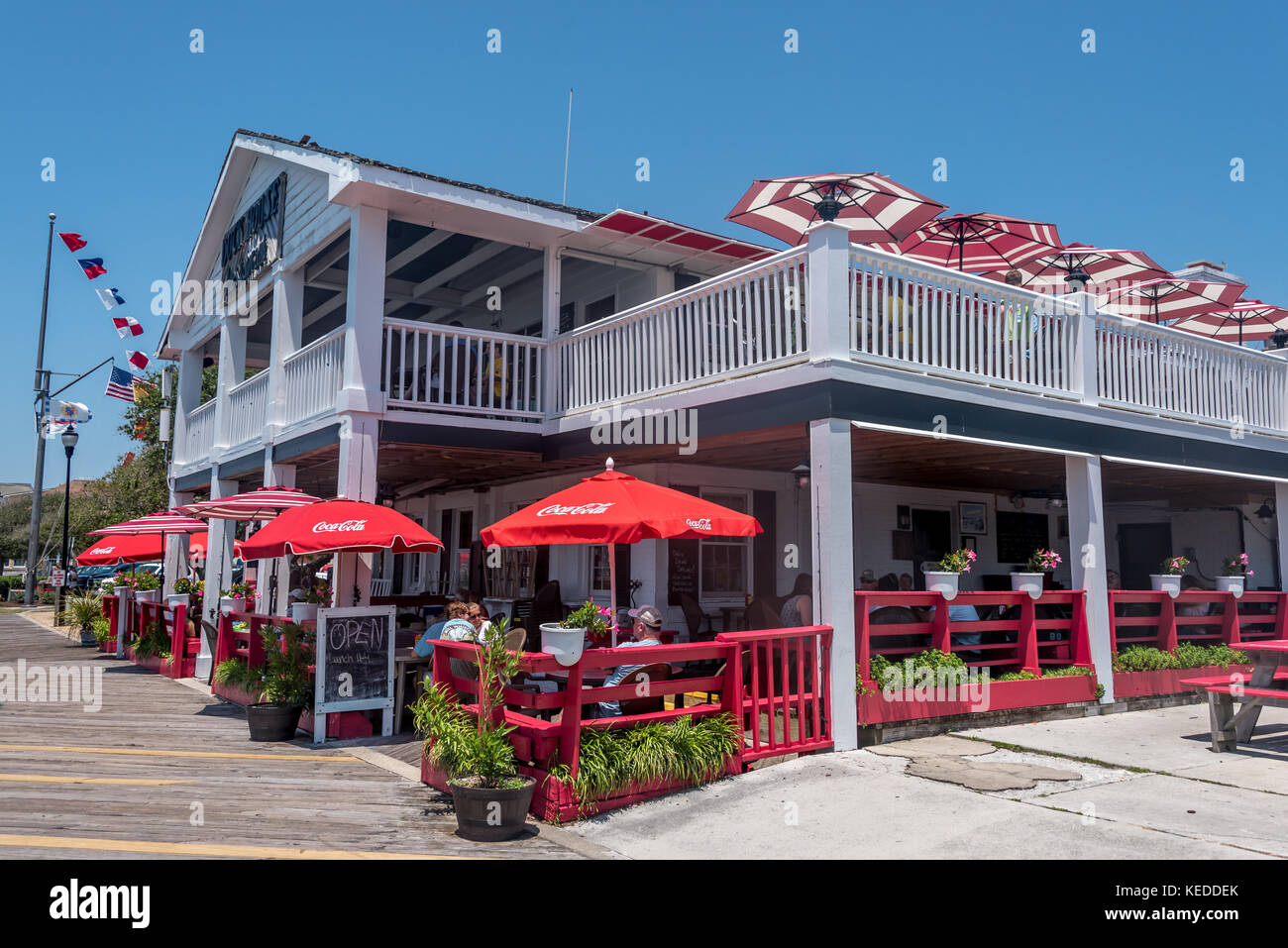Der Dock House Restaurant auf der Beaufort Wasser auf der Crystal Coast von Nord-carolina, mit fröhlichen roten Sonnenschirmen und im Freien speisen. Stockfoto
