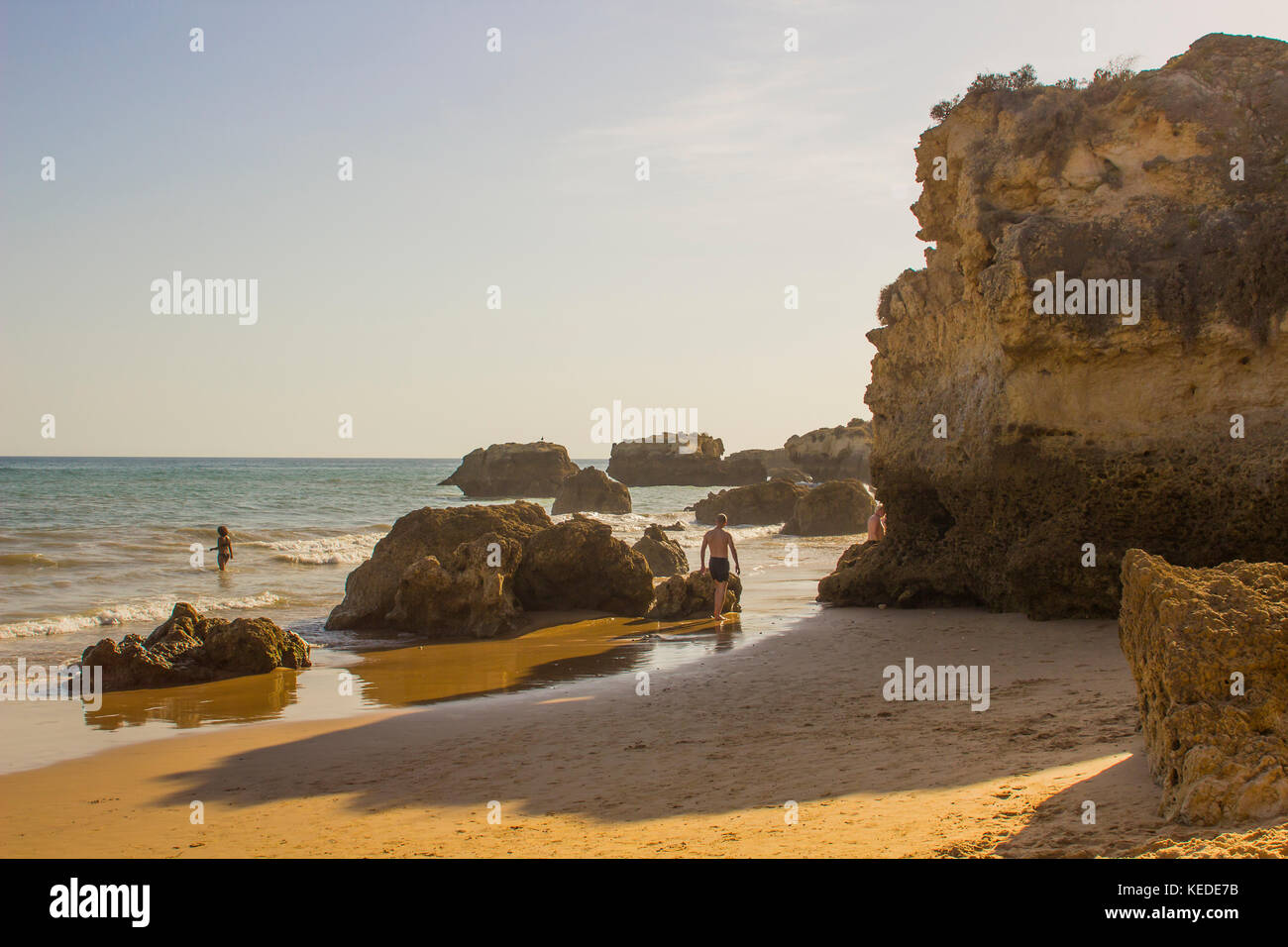 Urlauber unter den sedimentären Sandstein Felswand auf der Praia da Oura Strand in Albufeira. Stockfoto