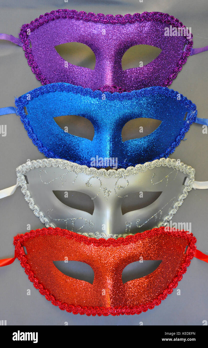 Bunte glitzernde Masken auf grauem Hintergrund Stockfoto