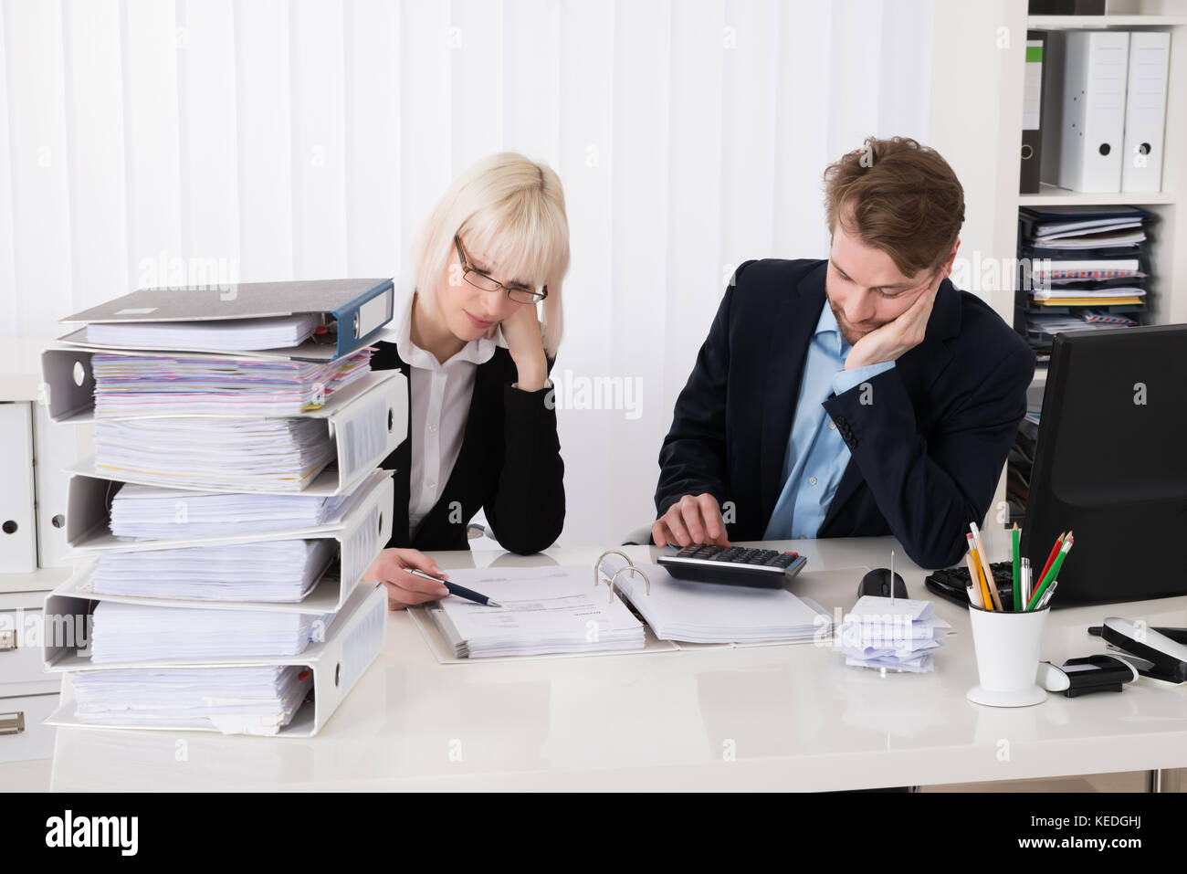 Zwei junge Unternehmer Berechnung von Rechnungen im Büro Stockfoto
