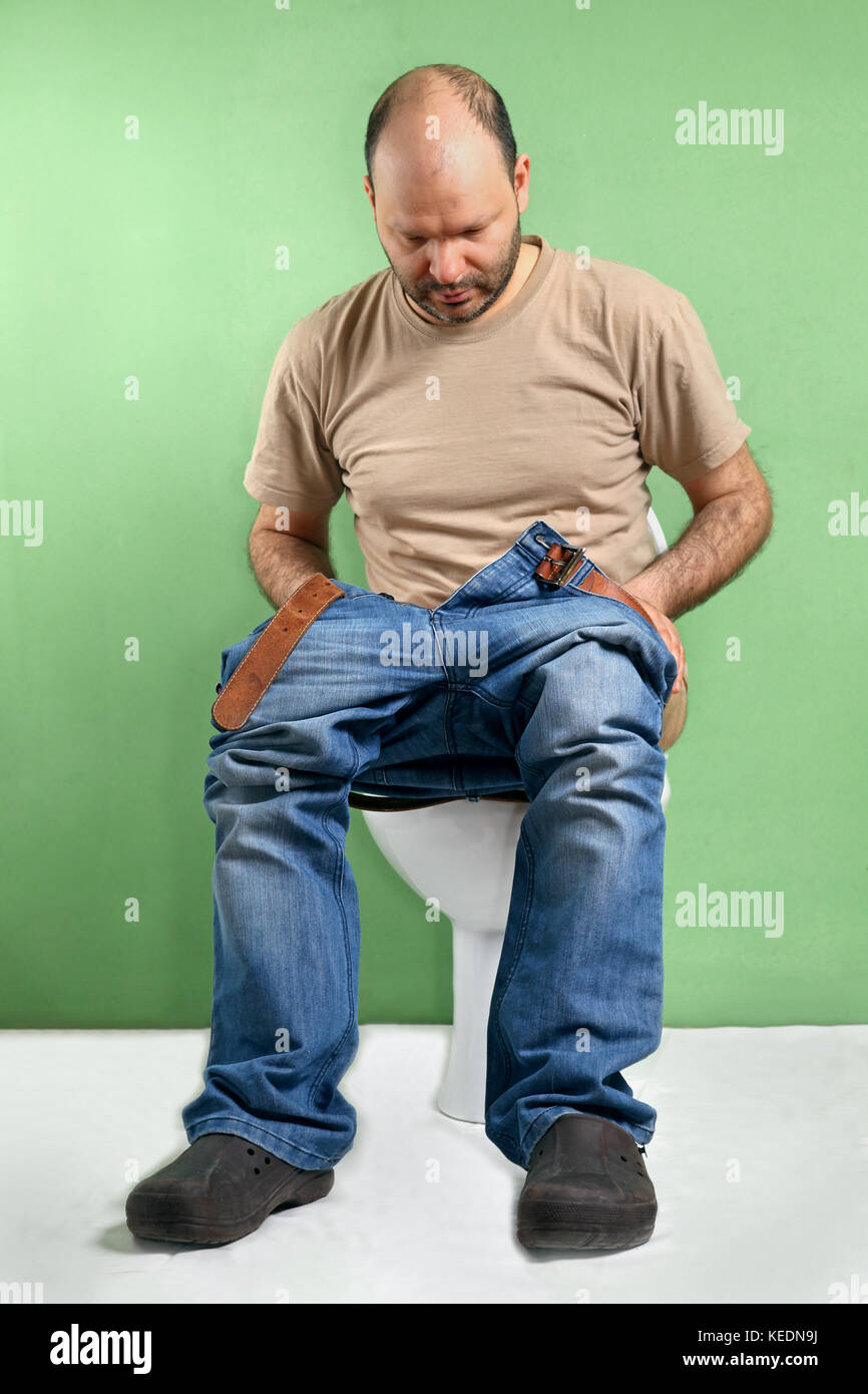 Mann sitzt auf der Toilette mit Durchfall, Magen-Darm-Grippe verursacht Stockfoto