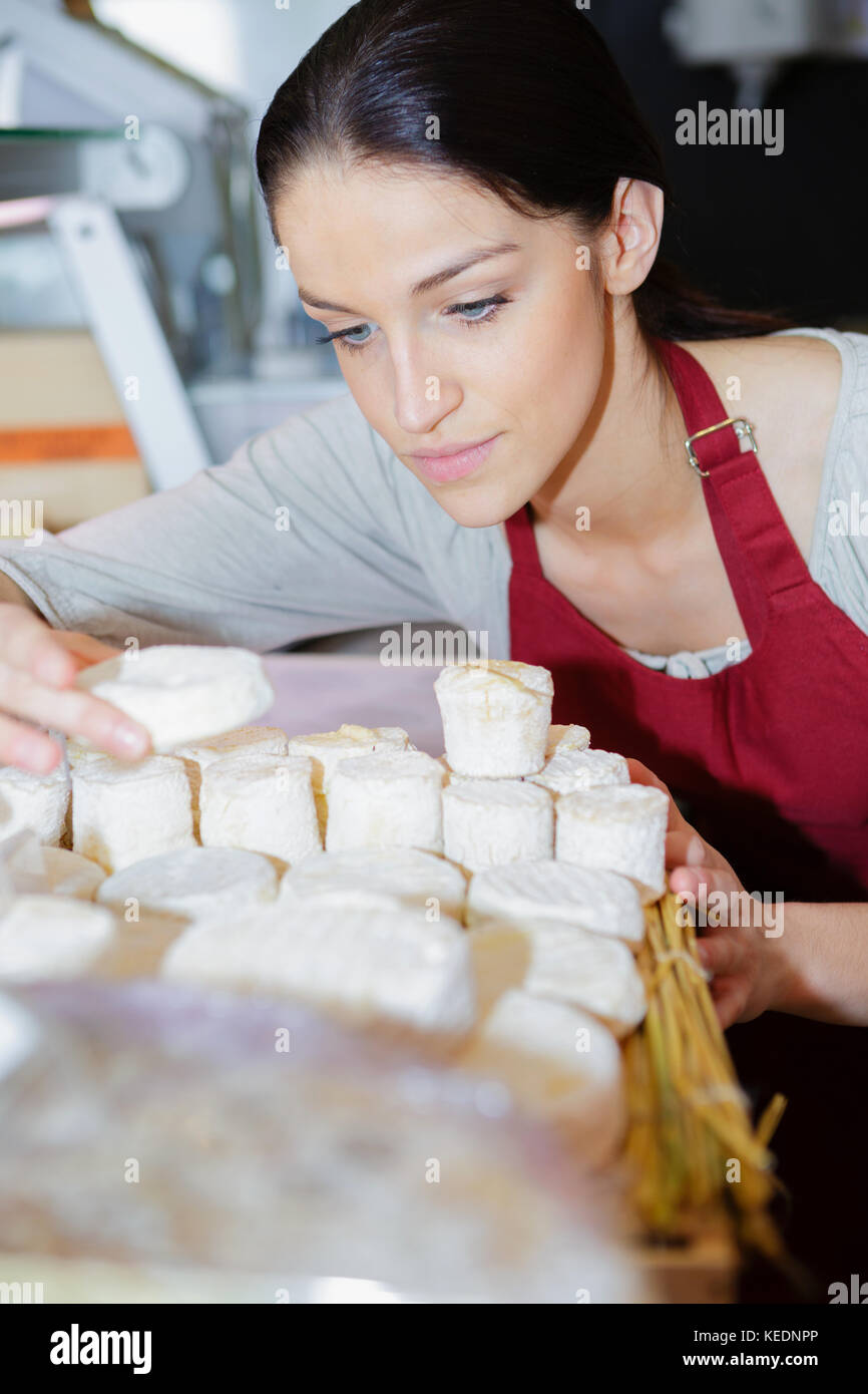 Fröhlicher junger shopgirl Verkauf von Käse Stockfoto