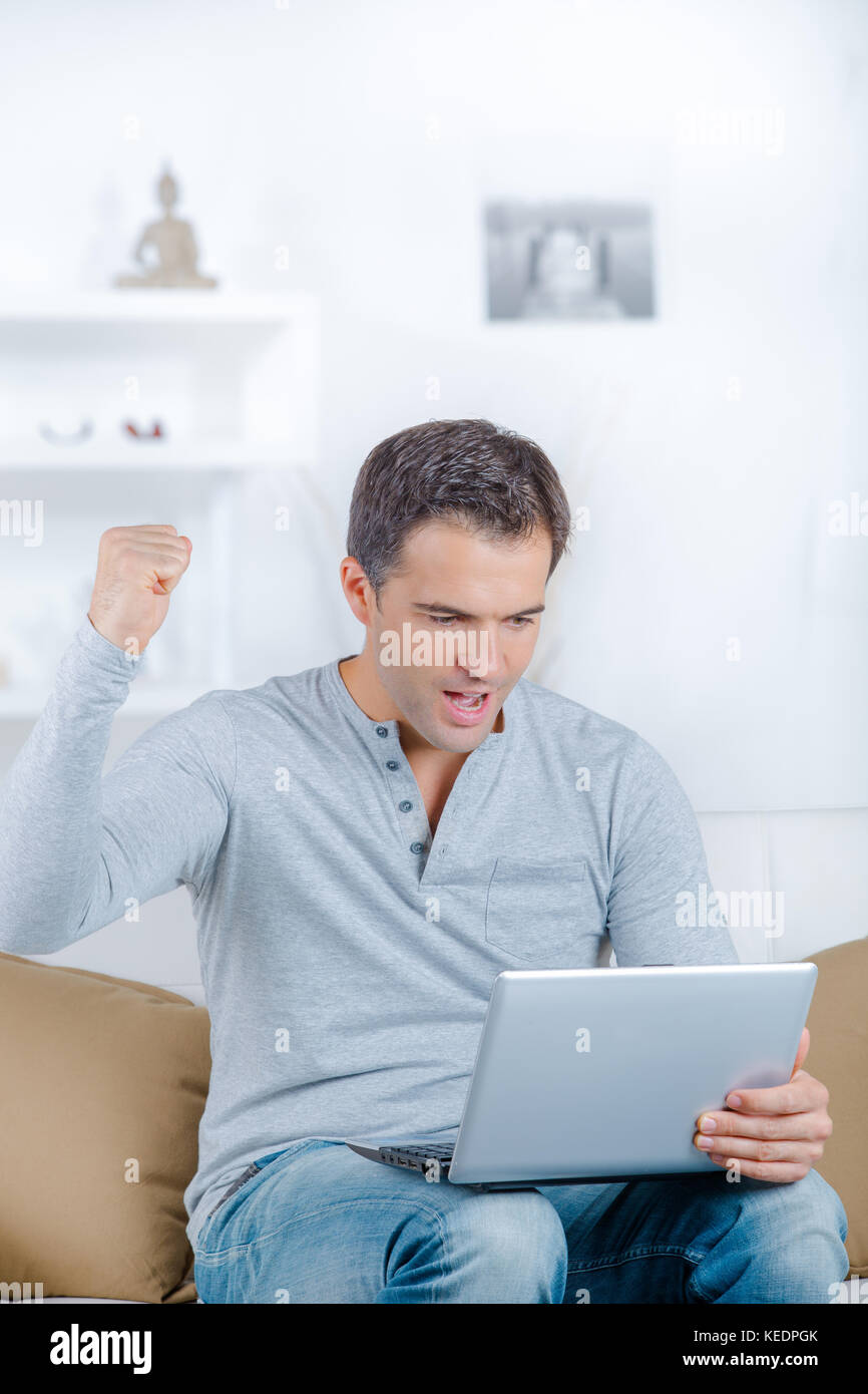 glücklicher Mann mit laptop Stockfoto