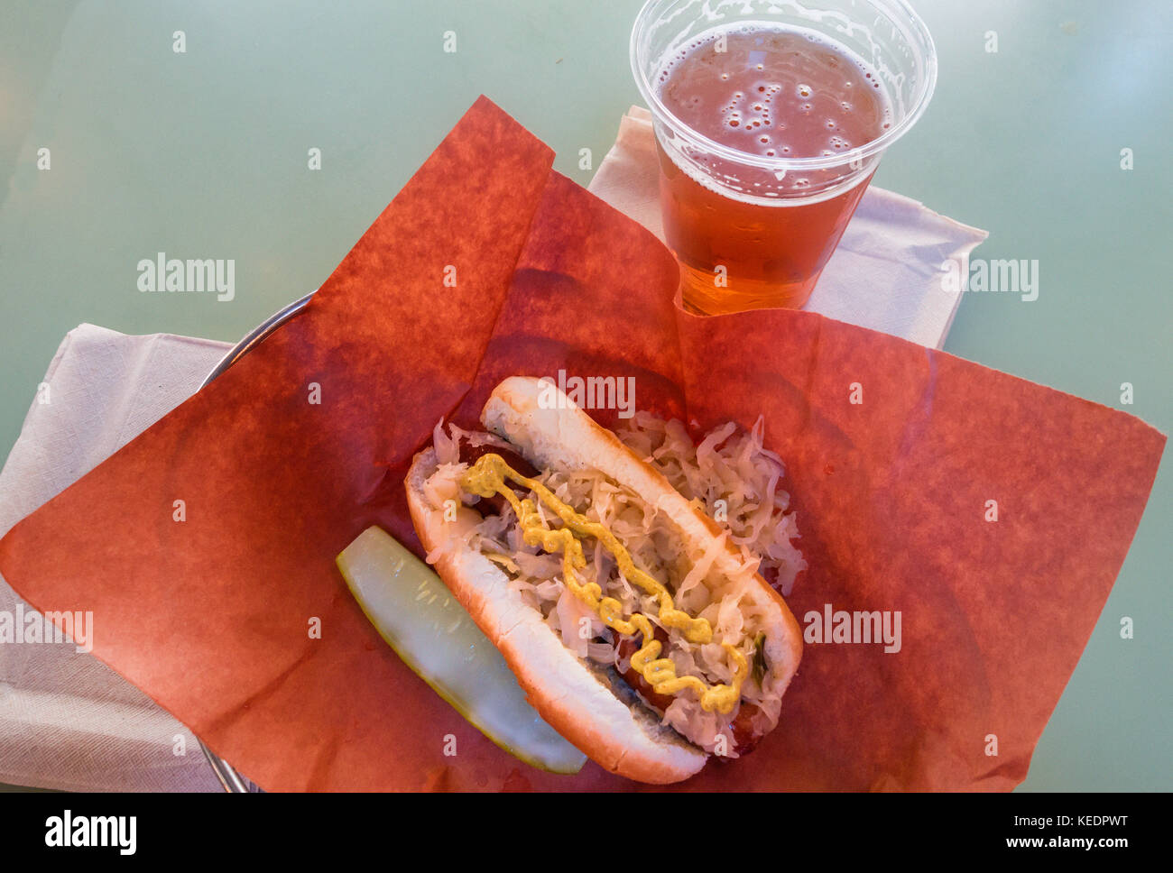 Hot Dog mit Sauerkraut und Senf und ein Bier Stockfoto