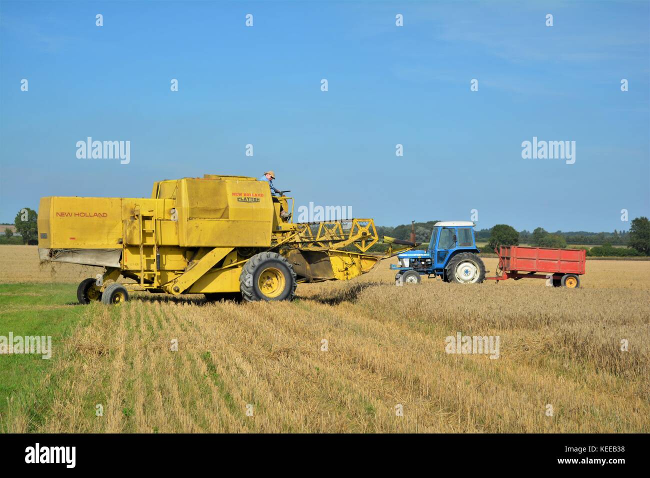 Alte offene Kabine gelb New Holland Mähdrescher Erntegut auf einem englischen Farm in 2017 Stockfoto