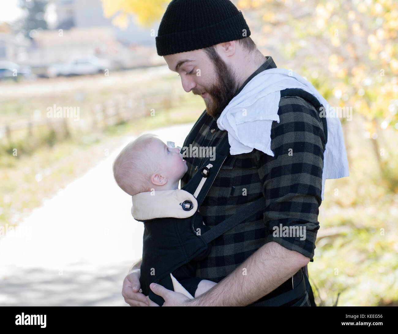 Tausendjährige Vati mit Baby im Träger außerhalb zu Fuß Stockfoto