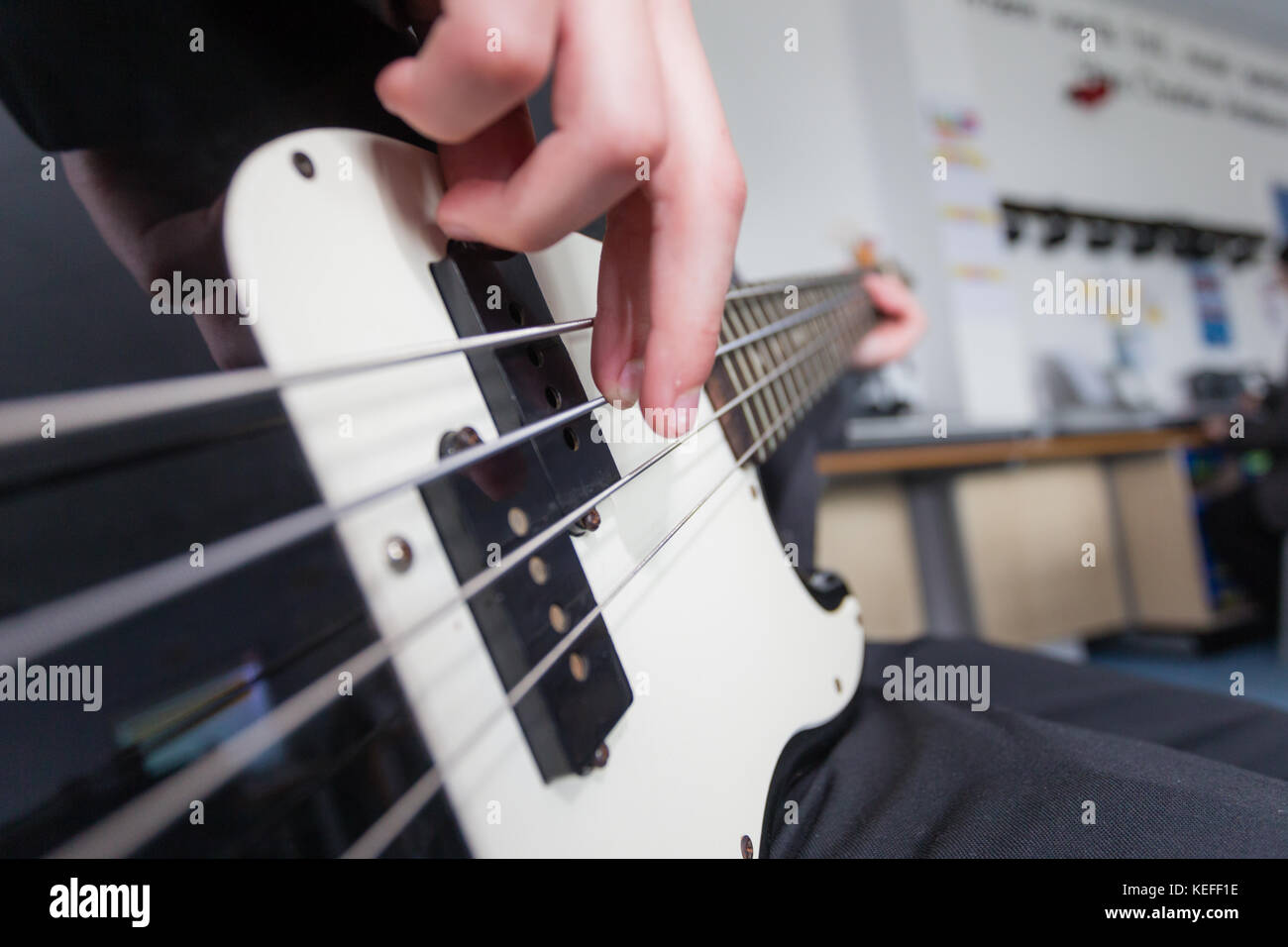 Schüler in einer britischen Schule, spielt den Bass in der Musik Lektion Stockfoto