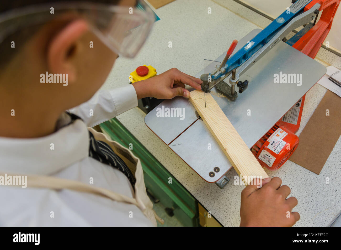 Schülerinnen und Schüler durch die werkbank Werkzeuge in eine Technologie Lektion UK Stockfoto