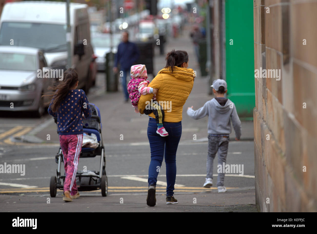 Ausländer zu Fuß auf der Straße Roma govanhill, Glasgow, Vereinigtes Königreich Stockfoto