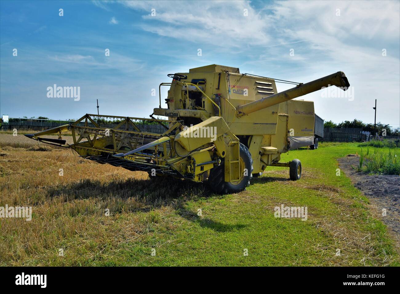 Alte offene Kabine gelb New Holland Mähdrescher Erntegut auf einem englischen Farm in 2017 Stockfoto