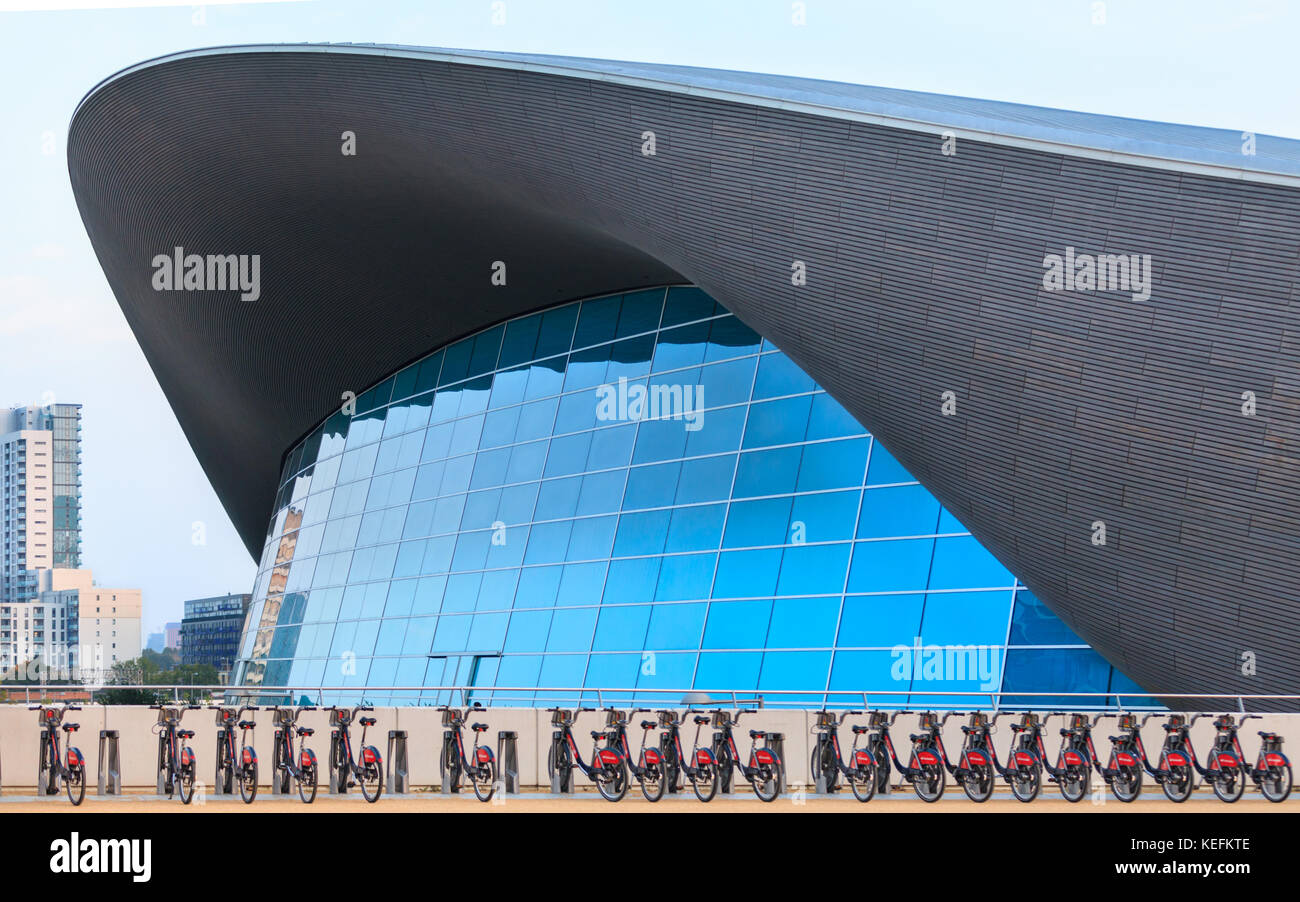 Die Aquatics Centre Außen, von Zaha Hadid, modernen Schwimmbad Sport Veranstaltungsort, bei der die Zeile der City Bikes vor, Queen Elizabeth Olympic Park Stratford, Lon Stockfoto