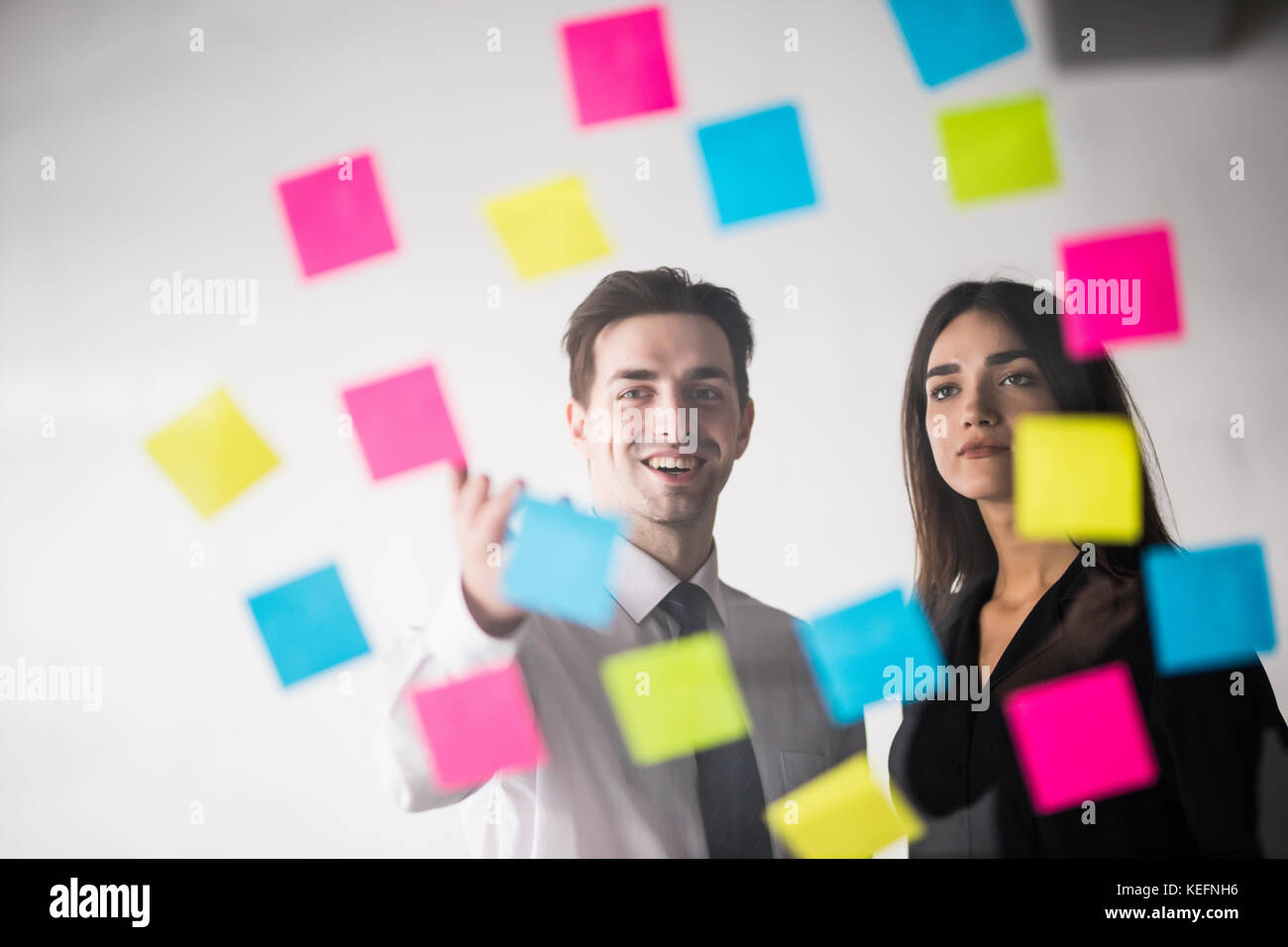 Start up Business Planung und Organisation mit junges Paar an moderne Büro innen schreiben Notizen auf Aufkleber Stockfoto