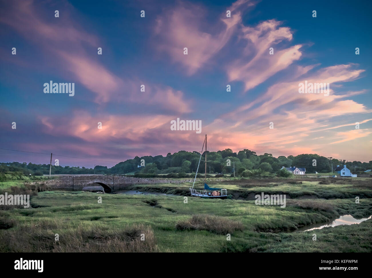 Red wharf Bay, pentreath, Anglesey, Wales, Ynys Mon, bei Sonnenuntergang, Brücke und Boot Stockfoto