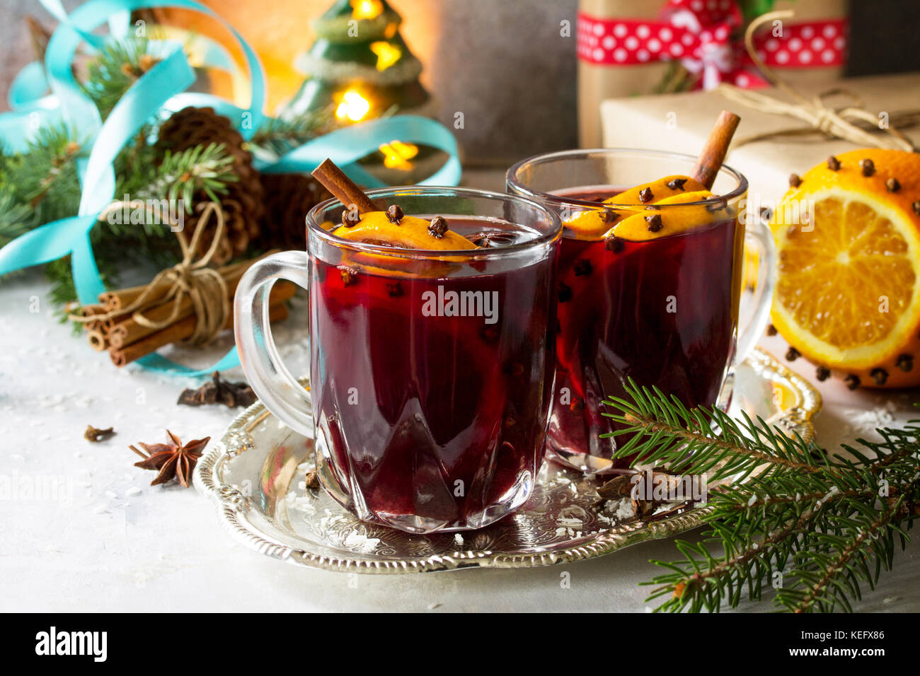 Hausgemachte Weihnachten cocktail Glühwein Rotwein mit Zimtstangen, Orangen und Nelken, in zwei Tassen serviert auf einem grauen Stein oder Schiefer. kopieren. Stockfoto