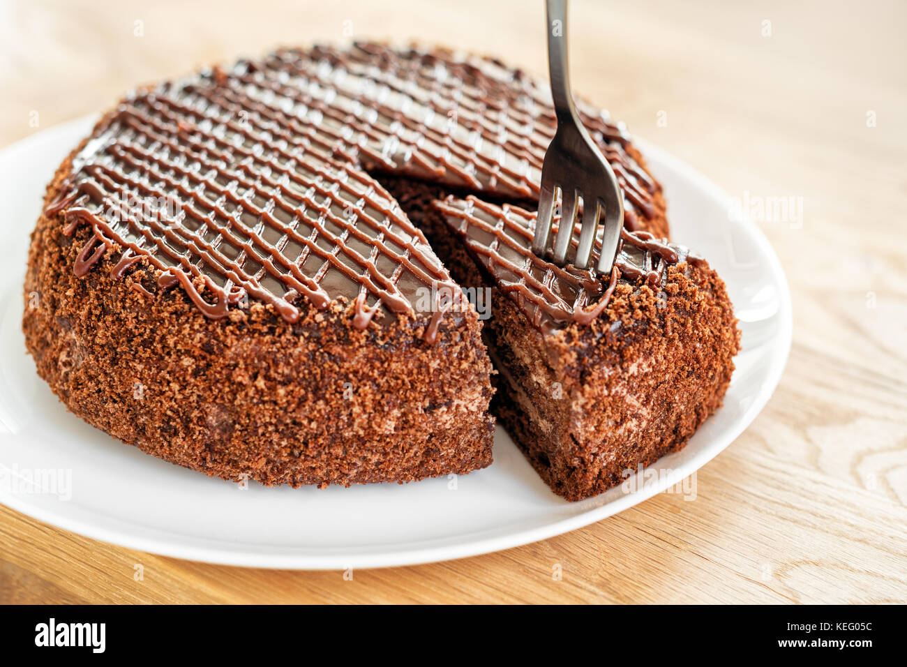 In Scheiben geschnitten serviert leckere Schokoladenkuchen auf hölzernen Tisch Hintergrund. Stop Diät Konzept, Ziel und Ende für gesundes Essen. Stockfoto